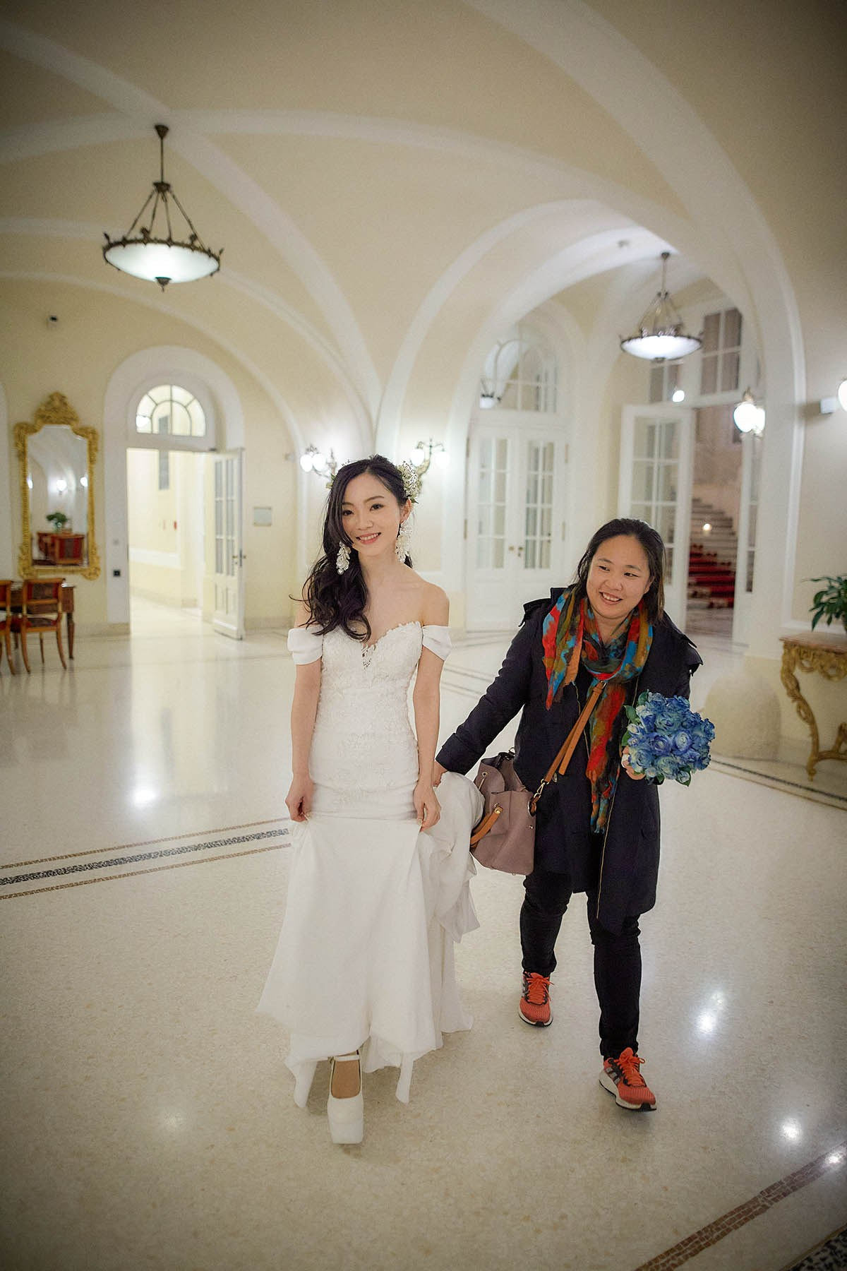 Bride walking assisted toward Clementine restaurant Palais Coburg.