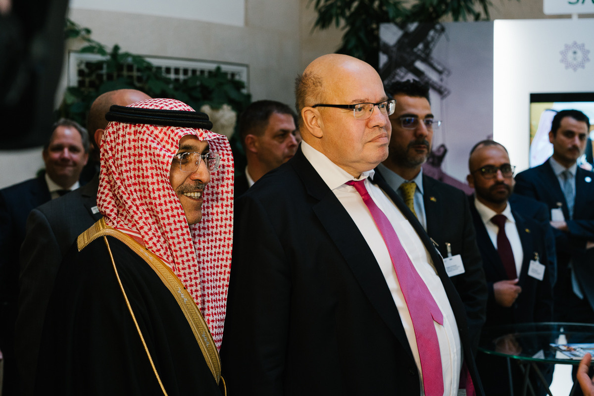 Senior officials and guests walking through trade fair area at high-level conference