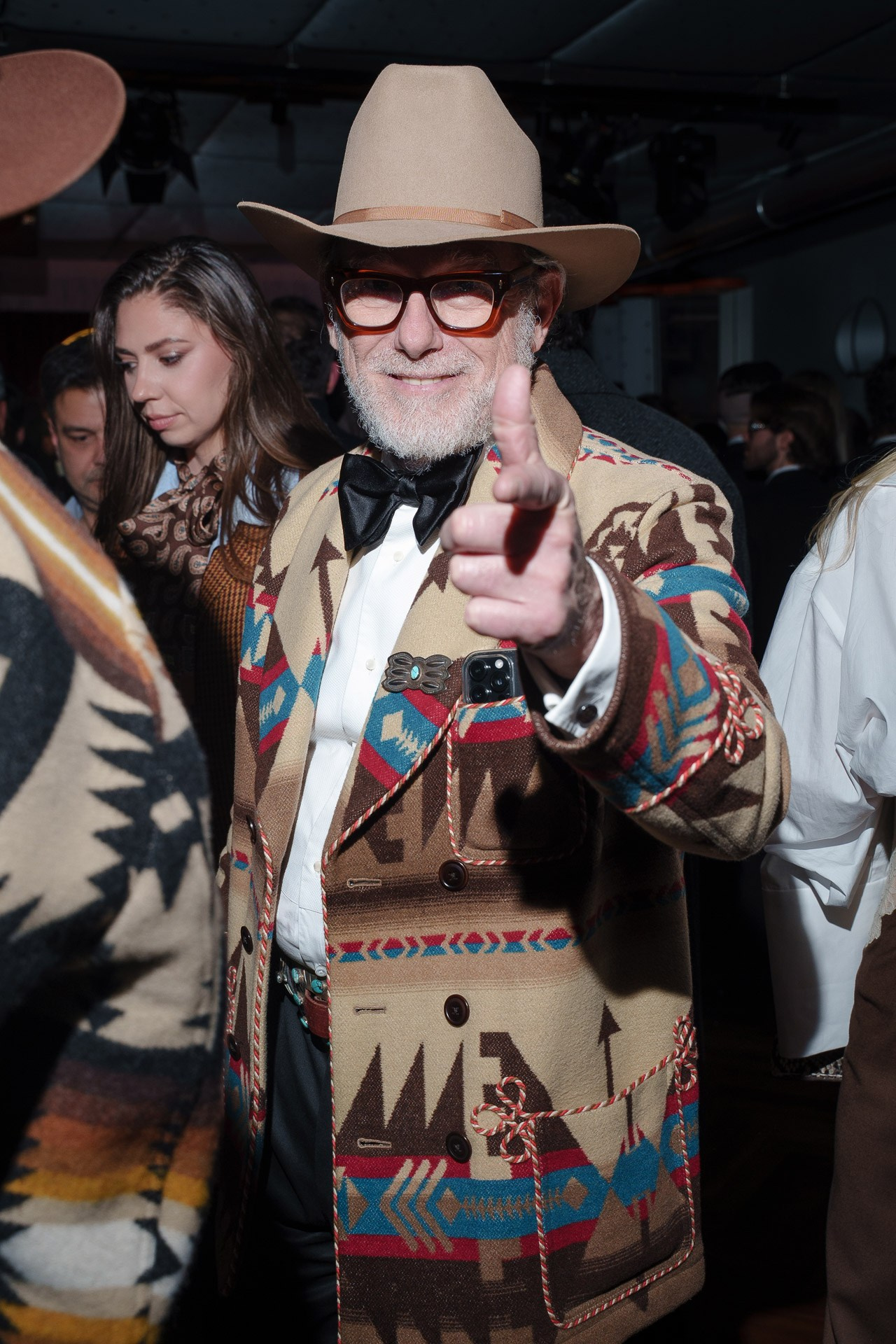 Guest in patterned jacket and hat posing during private cocktail event