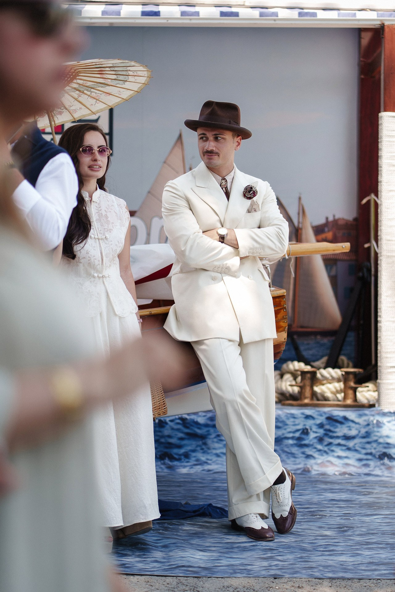 Ospiti di Pitti Uomo 110 in outfit estivi bianchi fotografati vicino a un’installazione a tema nautico