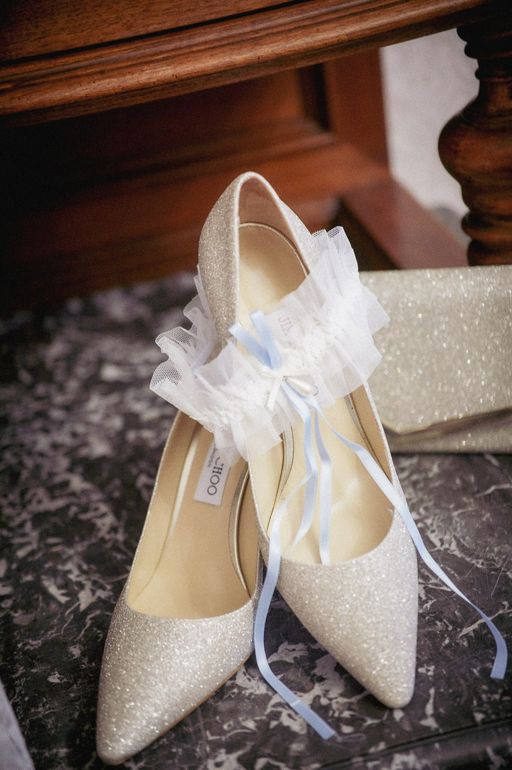 A cream-colored pair of Jimmy Choo shoes and the brides garter is seen in the suite during the bridal preparation in Prague.