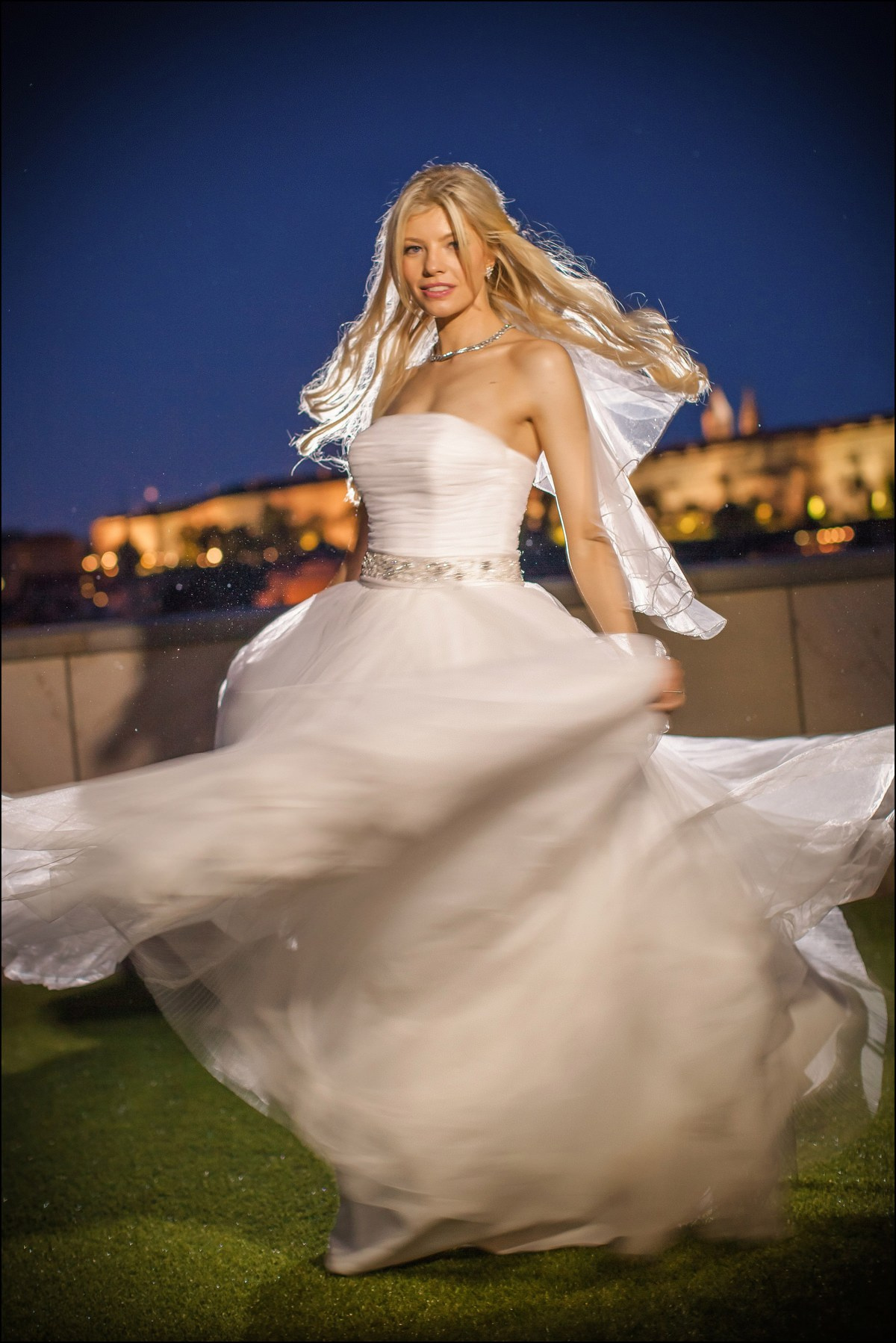 Radiant blonde bride twirling gown night portraits Prague