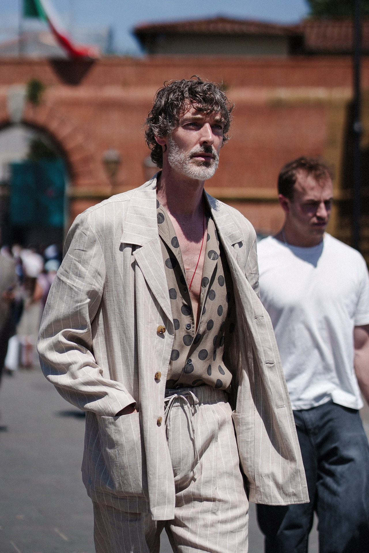 Ritratto menswear da Pitti Uomo 110, uomo in tailoring beige di lino e camicia fantasia a Firenze