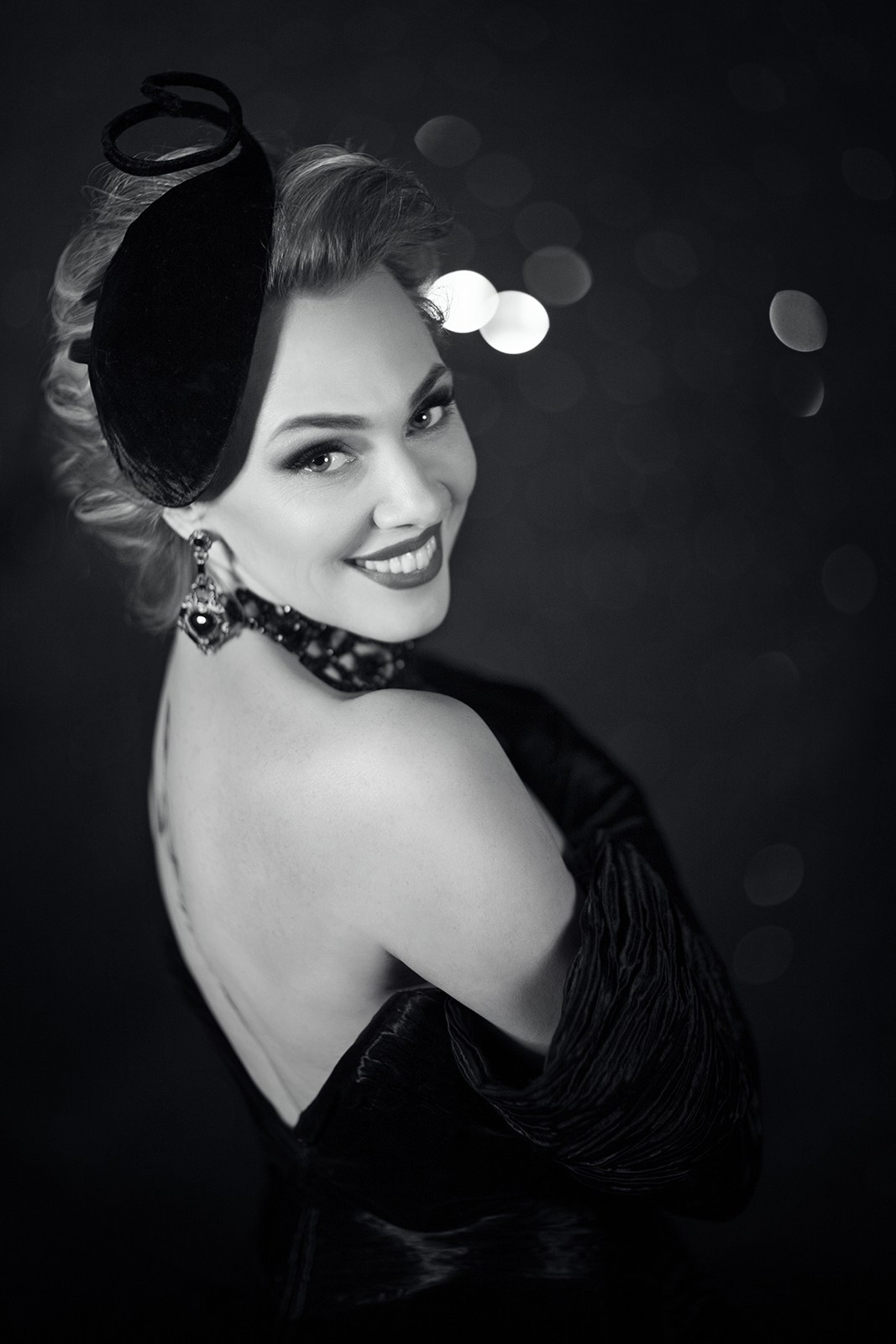 Гламурный чёрно-белый портрет женщины с вечерней причёской и открытой спиной
