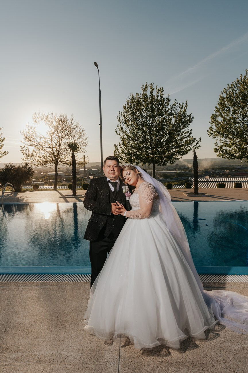 Cuplu de miri fotografiat lângă piscină