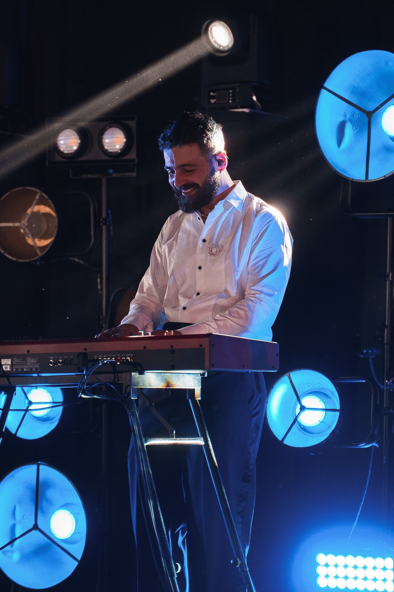 Live music performance at a corporate event in Milan featuring a professional keyboard player under cinematic spotlight.