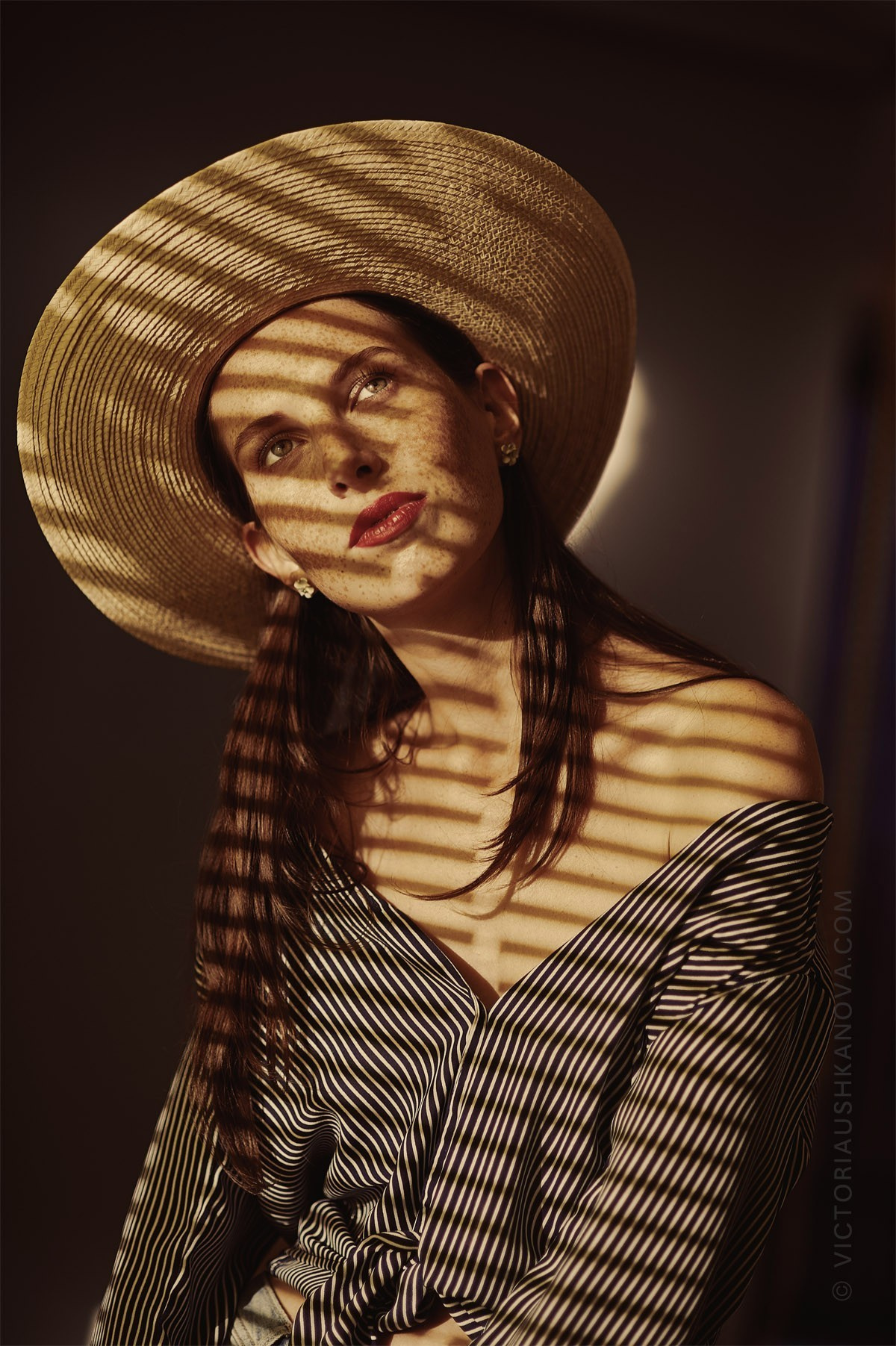 Portrait photographer young woman with stripes and a straw hat