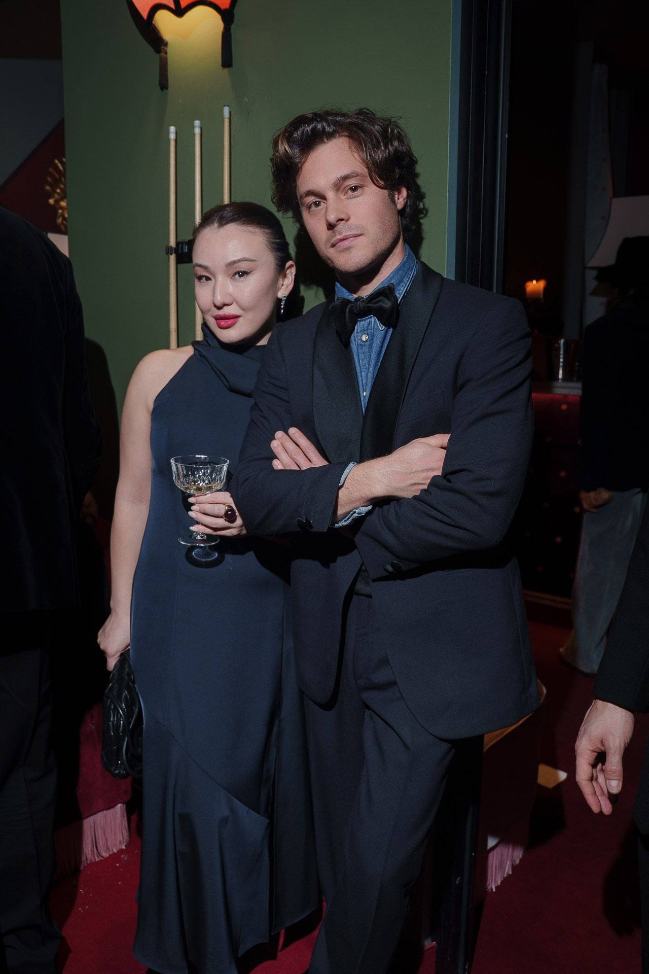Elegant couple in evening outfits holding drinks at luxury event