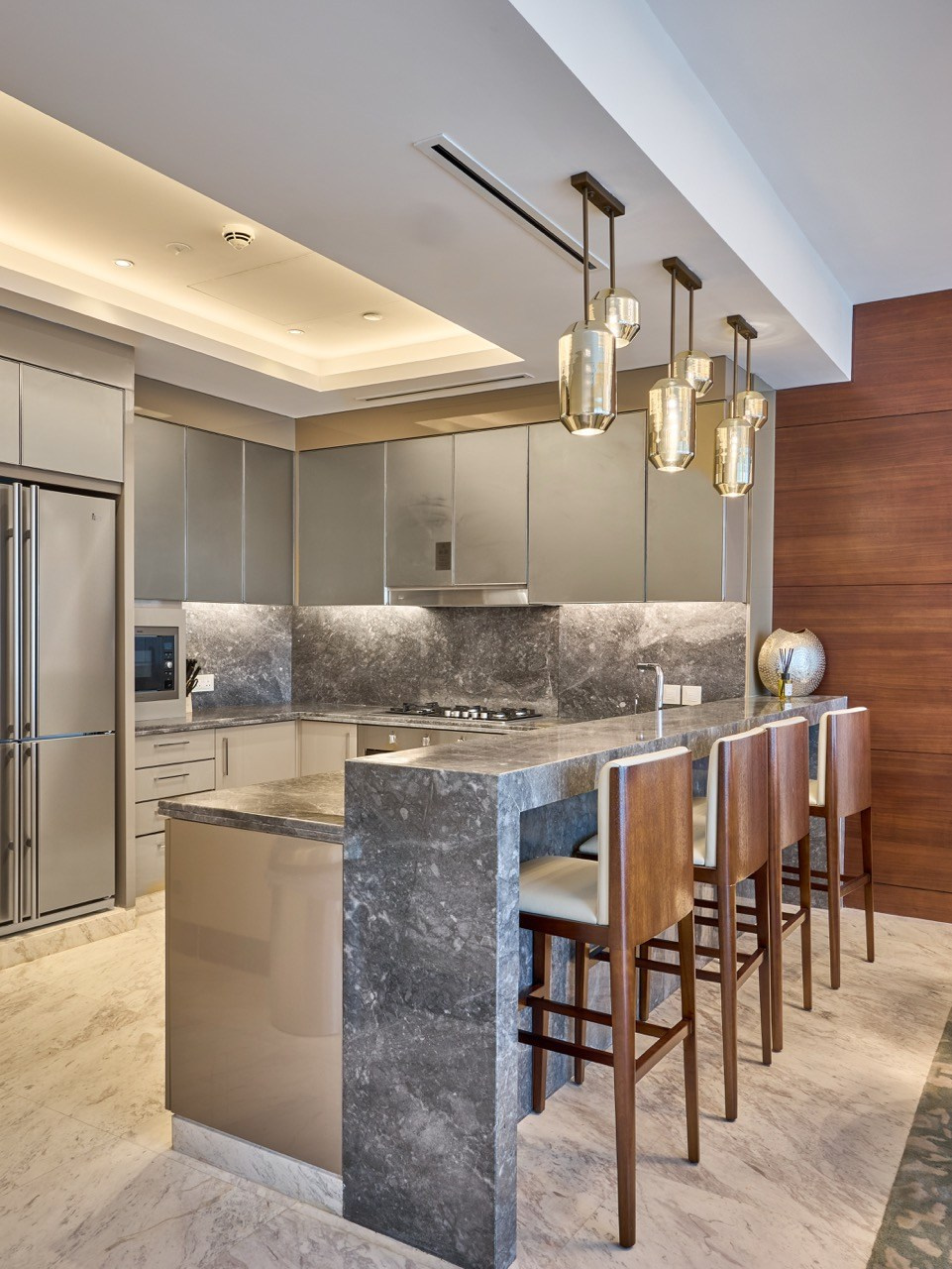 Bar-style kitchen with pendant lighting and marble counters, shot by hospitality and interior photographer.