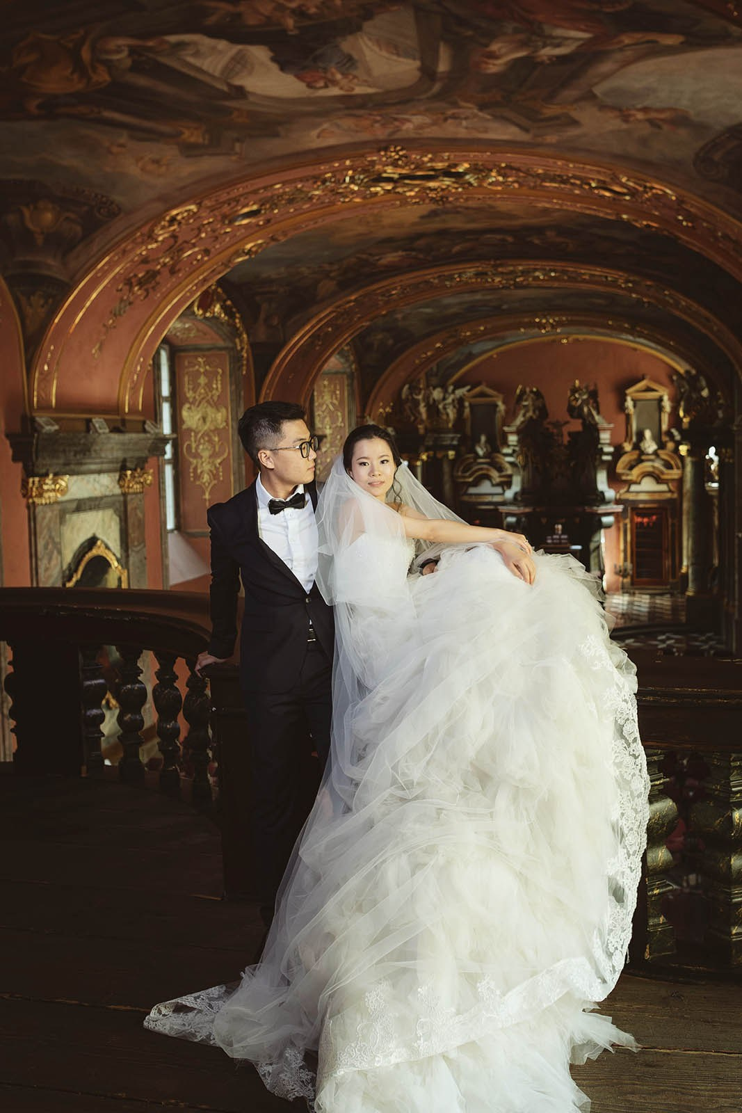 Chinese newlyweds sitting above the Mirror Chapel in Prague