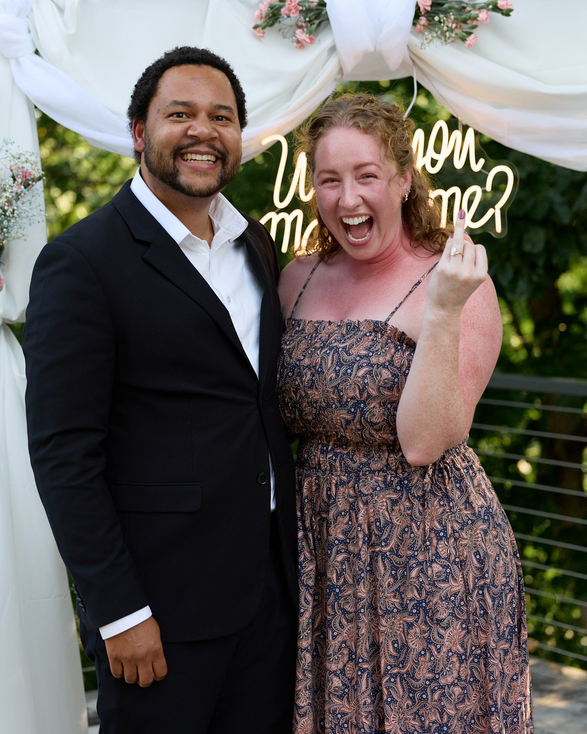 Engaged couple posing under the "Will you marry me?" sign in Dublin, Ohio
