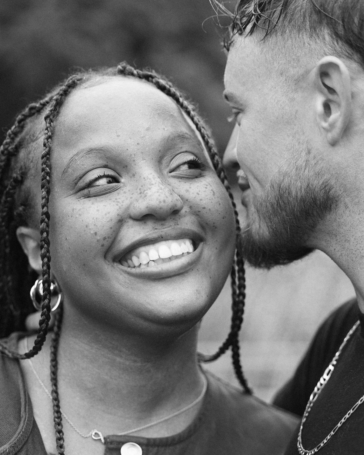 Black and white close-up of a smiling newly engaged couple at the Park of Roses in Columbus, Ohio