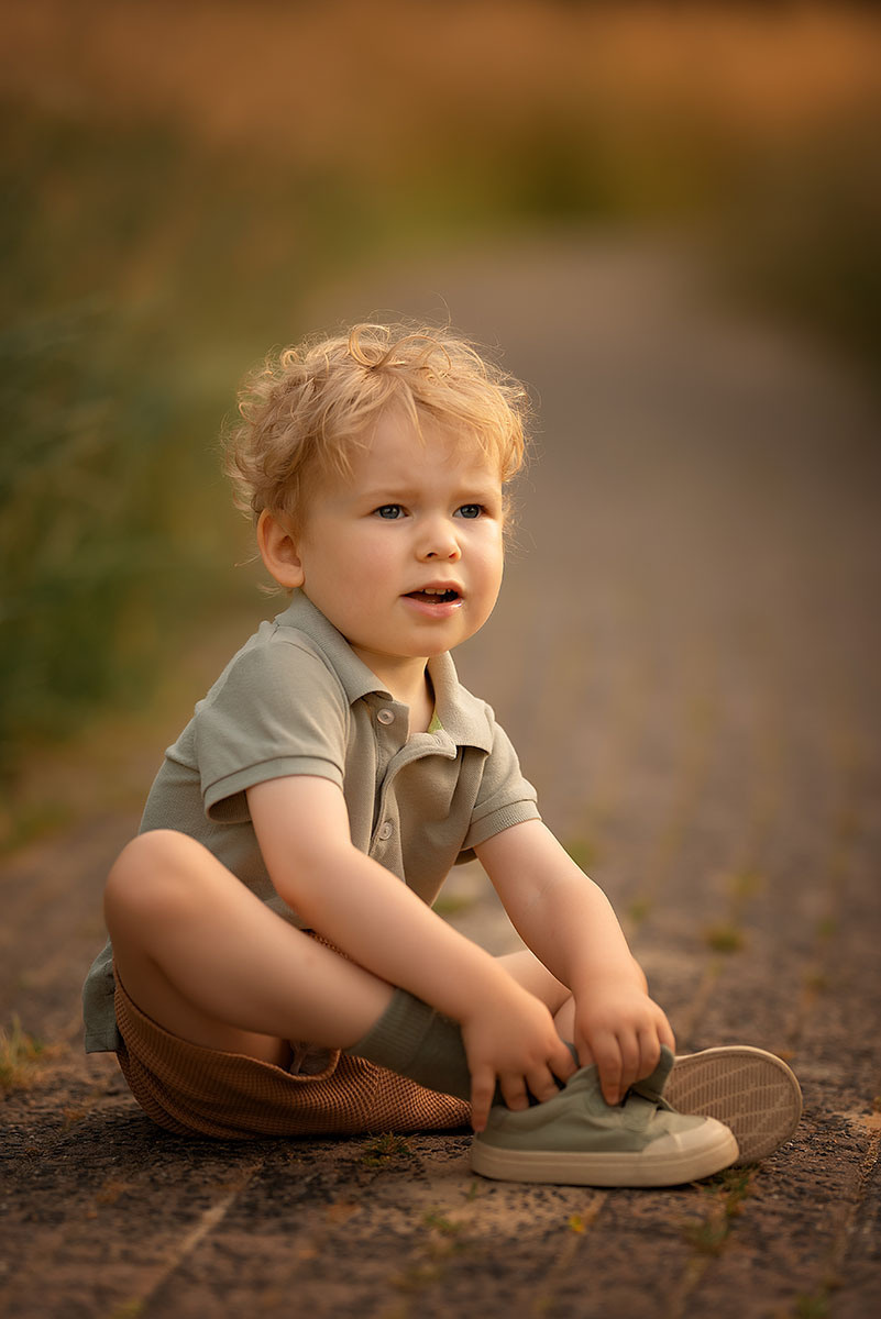 De jongen met zijn shoentje op het pad zomer fotoshoot