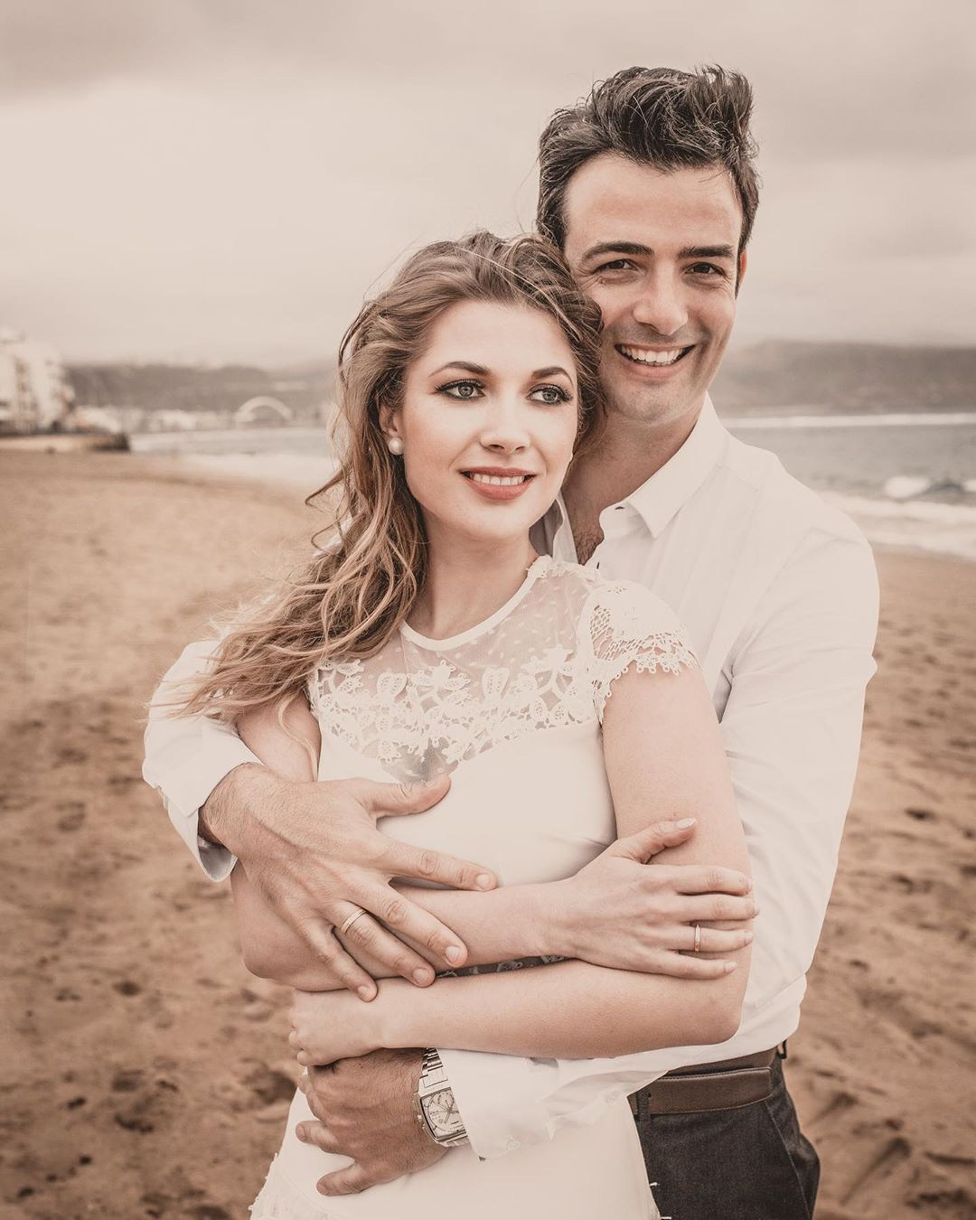 Une mariée et un marié s'embrassant sur la plage.