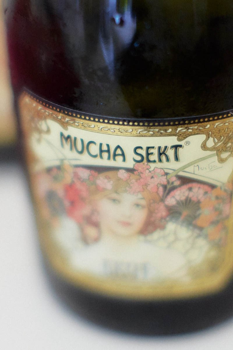 Alfons Mucha-inspired champagne bottles in moody bridal suite.