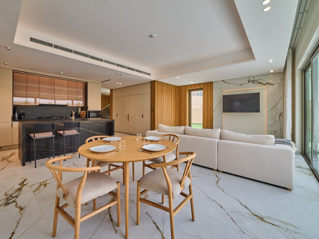 Open kitchen and cozy living room with soft tones, by luxury real estate photographer.