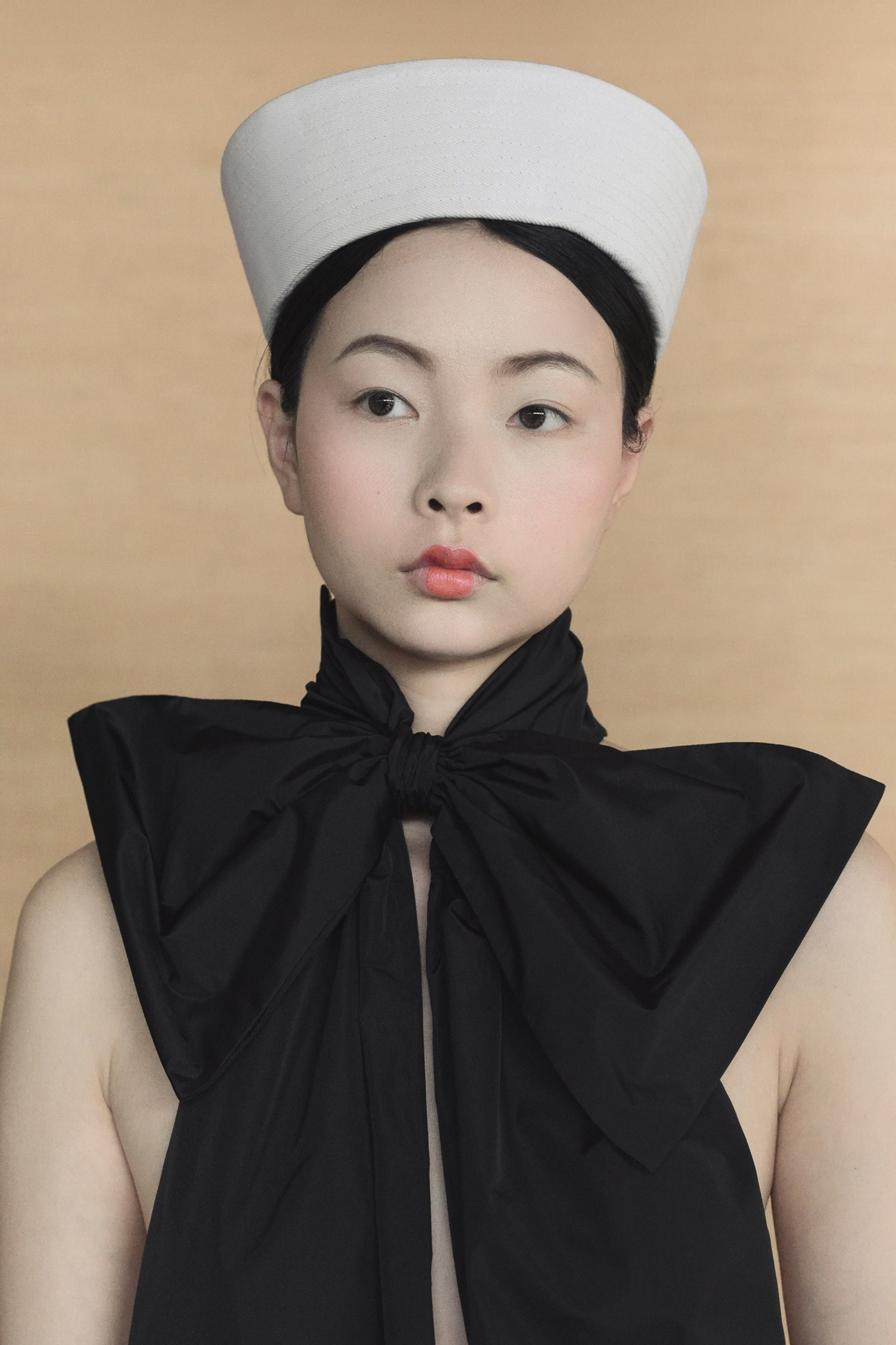 Asian inspired fashion portrait with sculptural headpiece and black bow