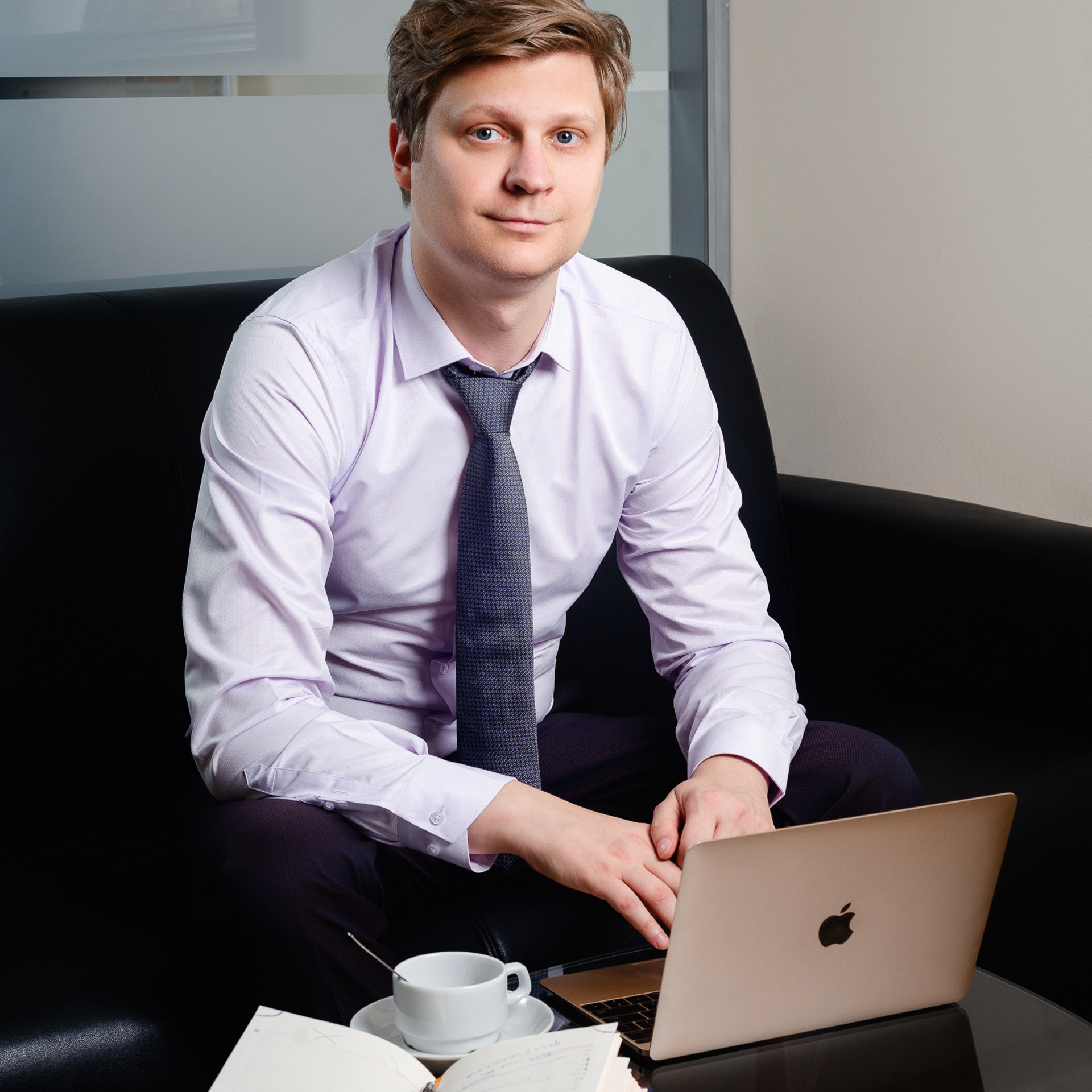 Focused executive working on a MacBook for business analysis, a corporate portrait by Dmitrii Shmatov reflecting professional dedication