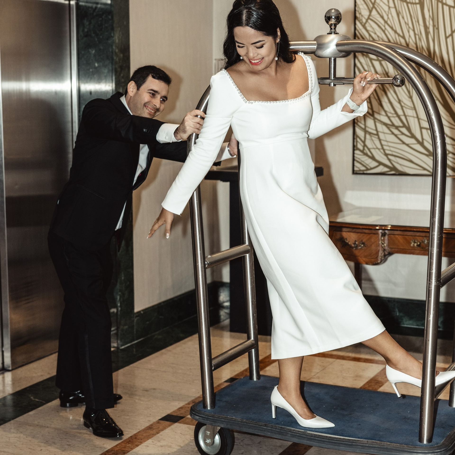 Bruidegom helpt de bruid bij de ingang van een hotel