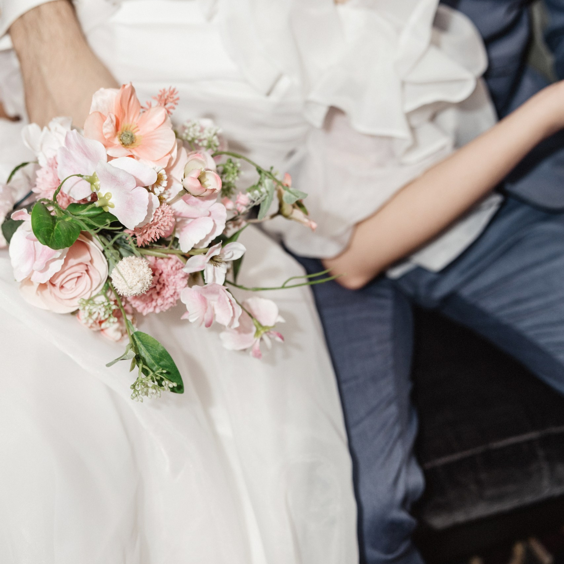 Bruid houdt haar bruidsboeket vast tijdens een rustig moment in de auto