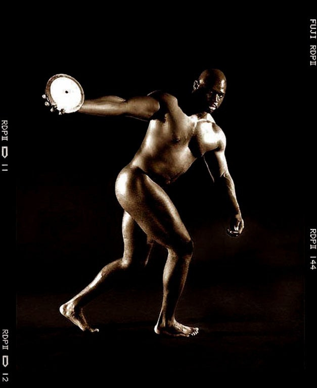 Monochrome portrait of a nude athlete posing with a discuss.