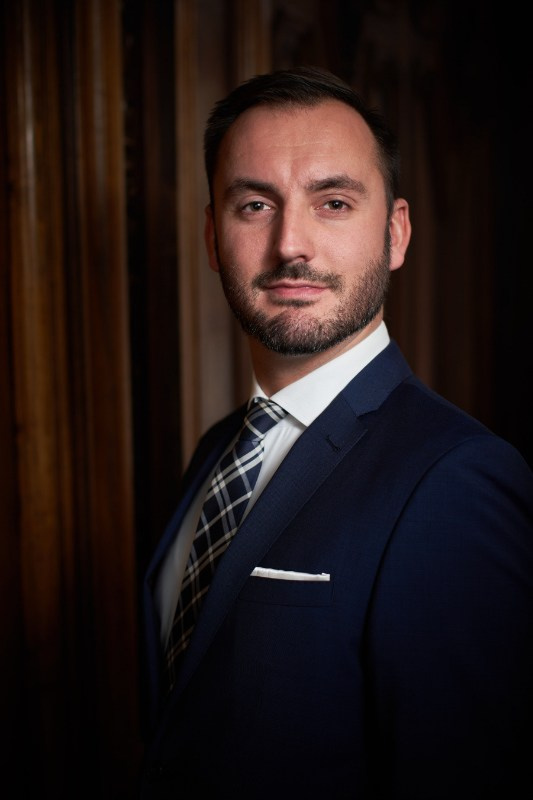 Corporate lawyer headshot in Prague office with wood panel background