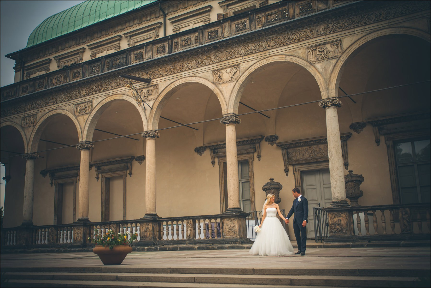Couple walking along Renaissance architecture Belvedere Prague wedding