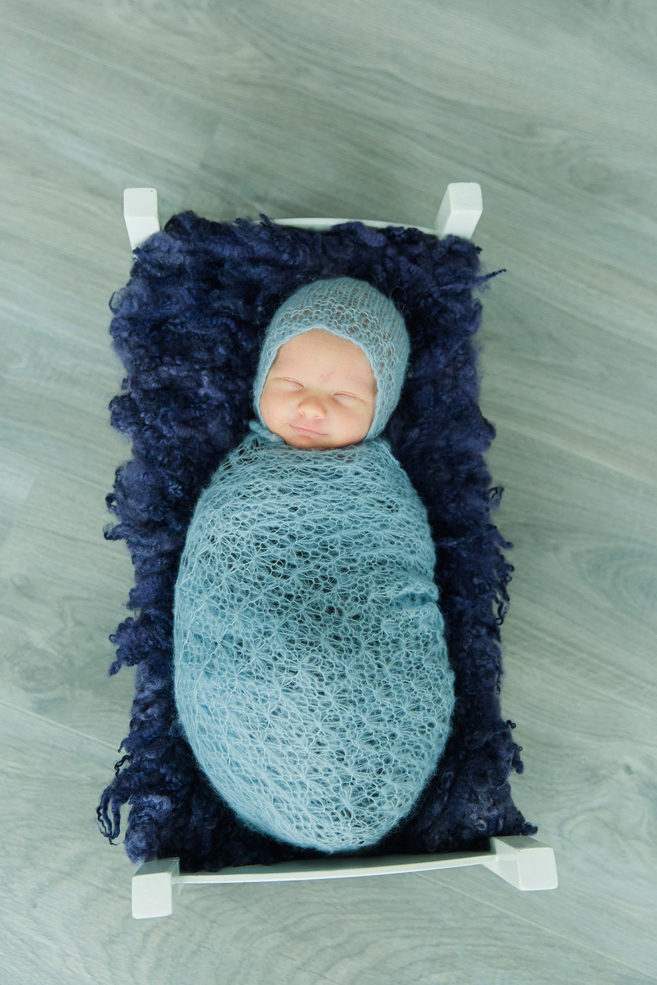 Vastasyntynyt poikavauva nukkuu lämpimään kapaloon käärittynä