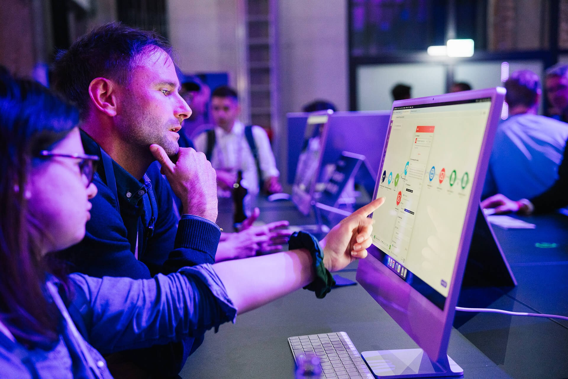Teilnehmende testen ein interaktives Produktdisplay am Messestand