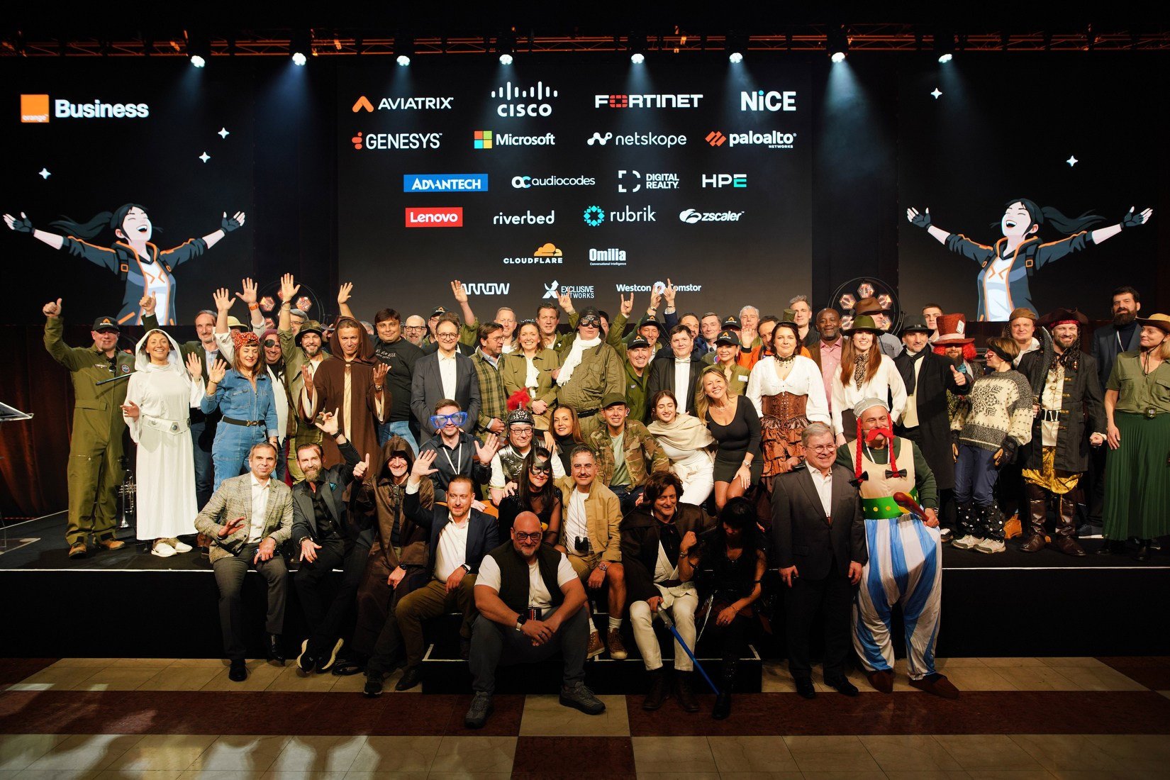 Attendees in adventure-themed costumes group photo Orange Business gala dinner Hilton Prague 2026.