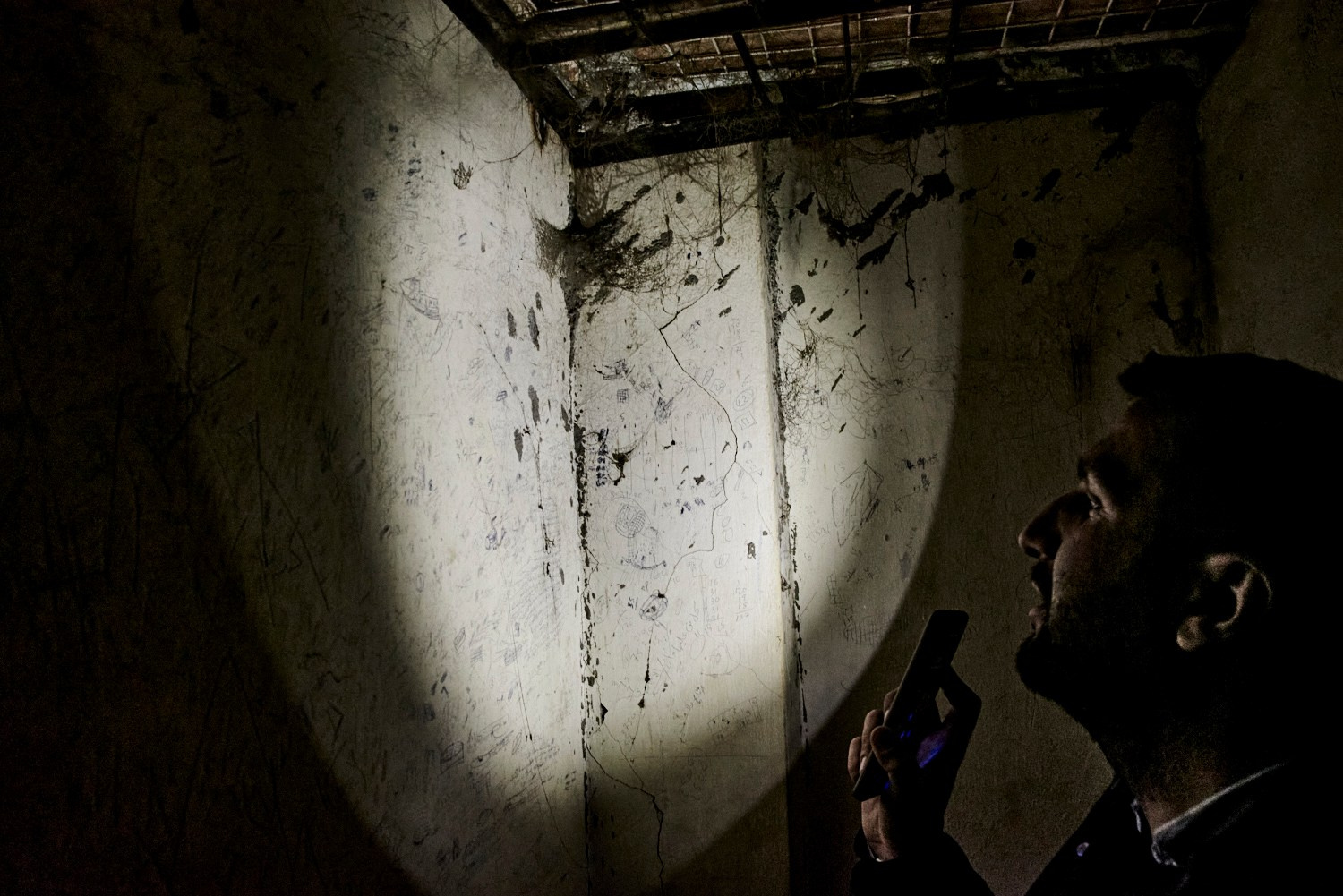 Raqqa, 9 février 2025 – Inscriptions laissées par les prisonniers sur les murs des souterrains du stade de Raqqa, qui abritait le quartier général et les geôles de Daech lorsque les djihadistes contrôlaient la ville. Aujourd'hui, les membres de la Syrian Missing Persons and Forensic Team prévoient de transformer cet endroit de sinistre réputation en un lieu de mémoire ouvert à la visite.