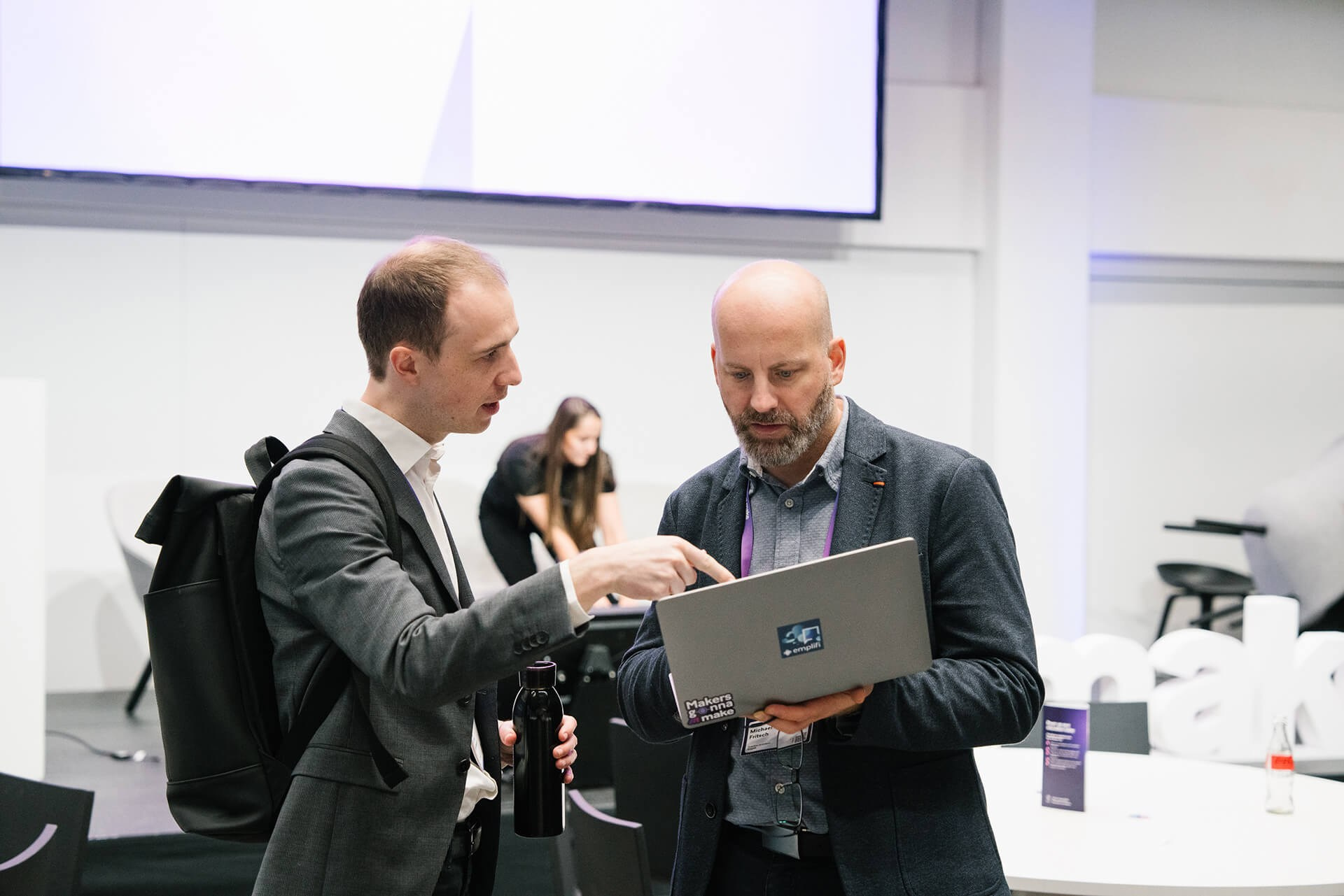 Zwei Männer im Gespräch und beim Prüfen von Unterlagen während eines Business-Events