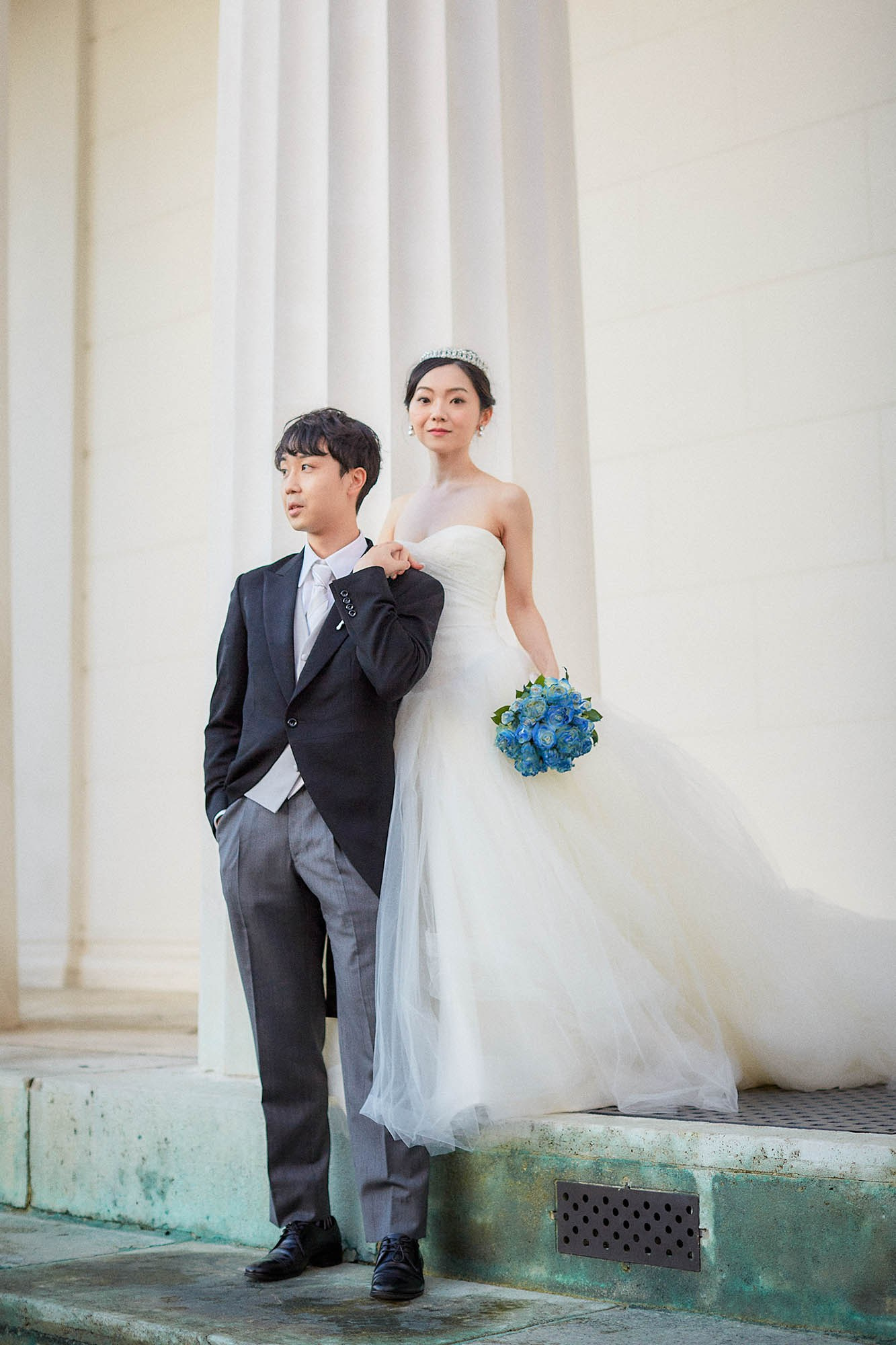 Newlyweds portrait near colonnade in cold Volksgarten.