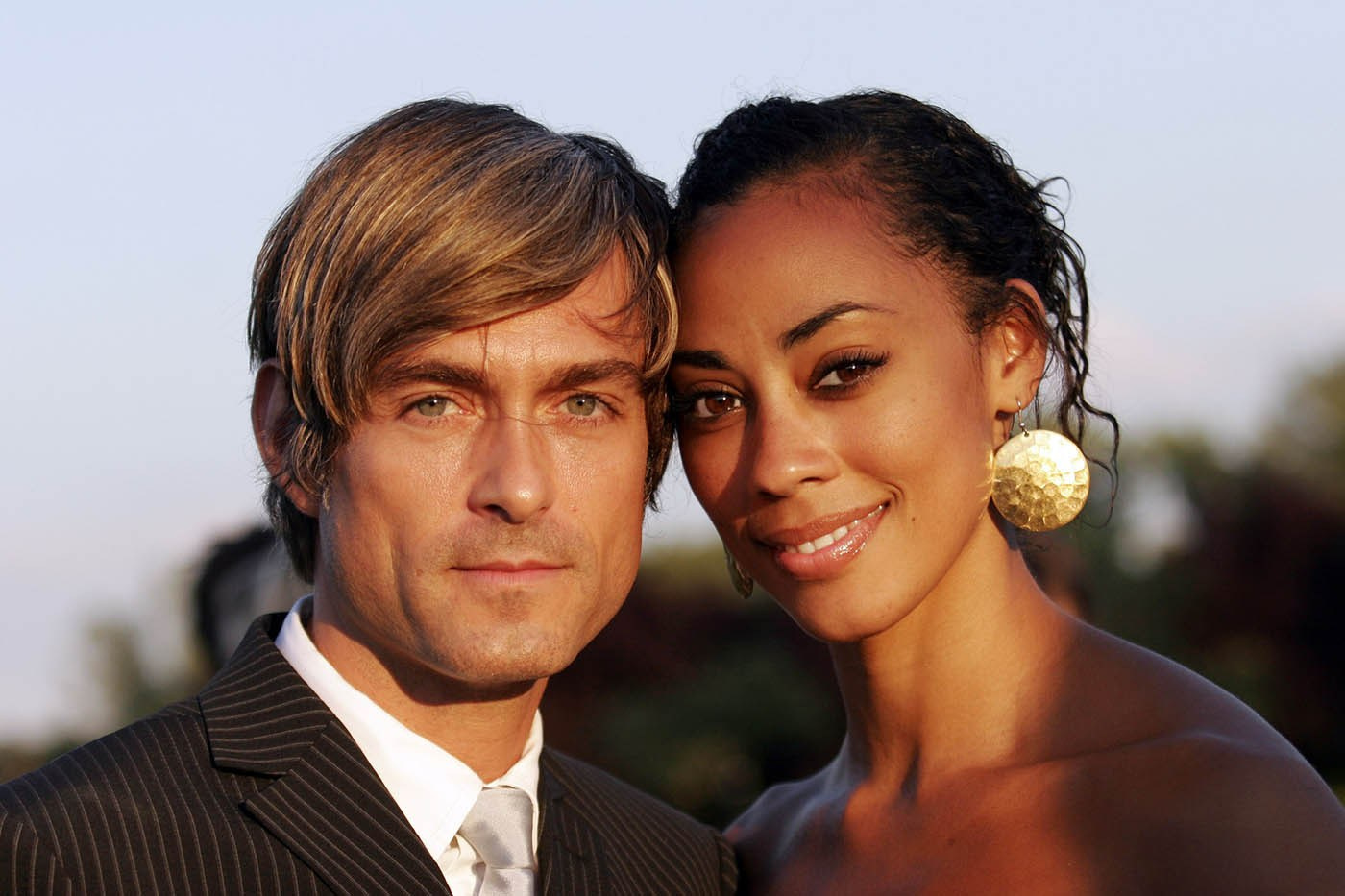 Elegant couple posing cheek to cheek for a portrait at a private VIP event in Troja Chateau, Prague.