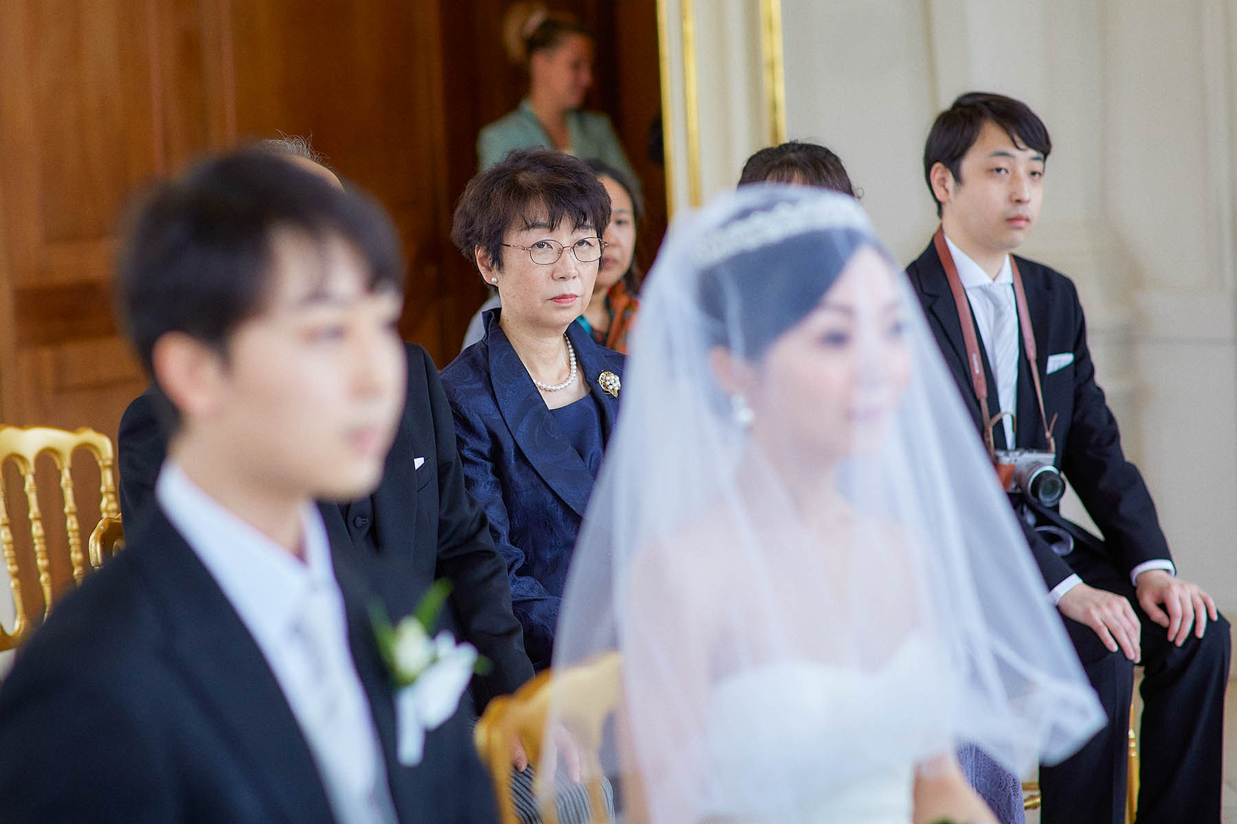 The bride's mother looks on.