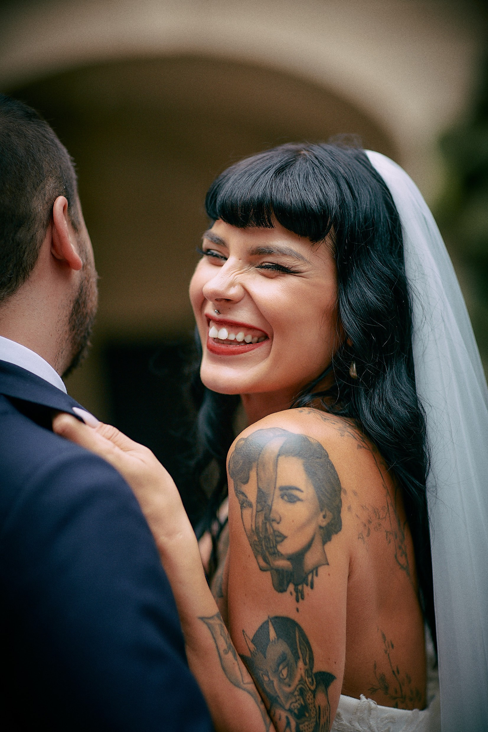 Groom squeezing tattooed bride tightly in hidden Grebovka grotto.