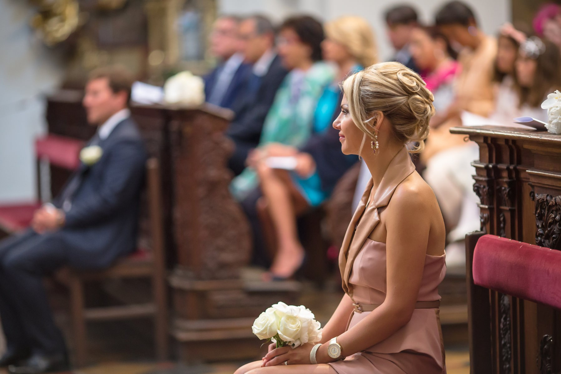 Bridesmaid seated in reverence during ceremony at St. Thomas Church Prague