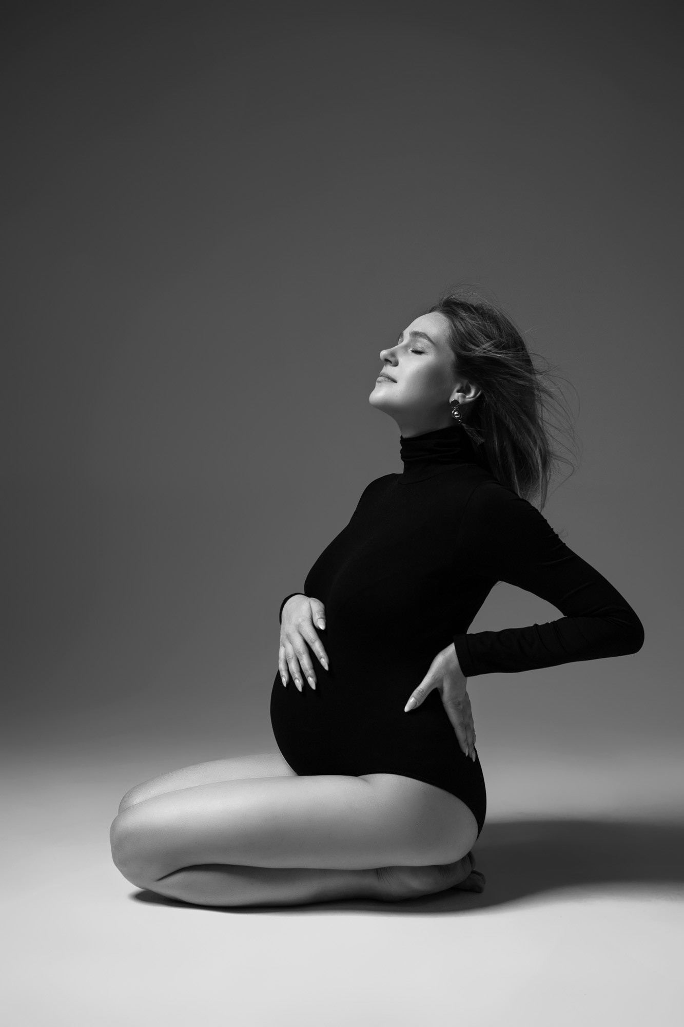 Babybauchshooting im Studio mit junger Frau in schwarzem Bodie