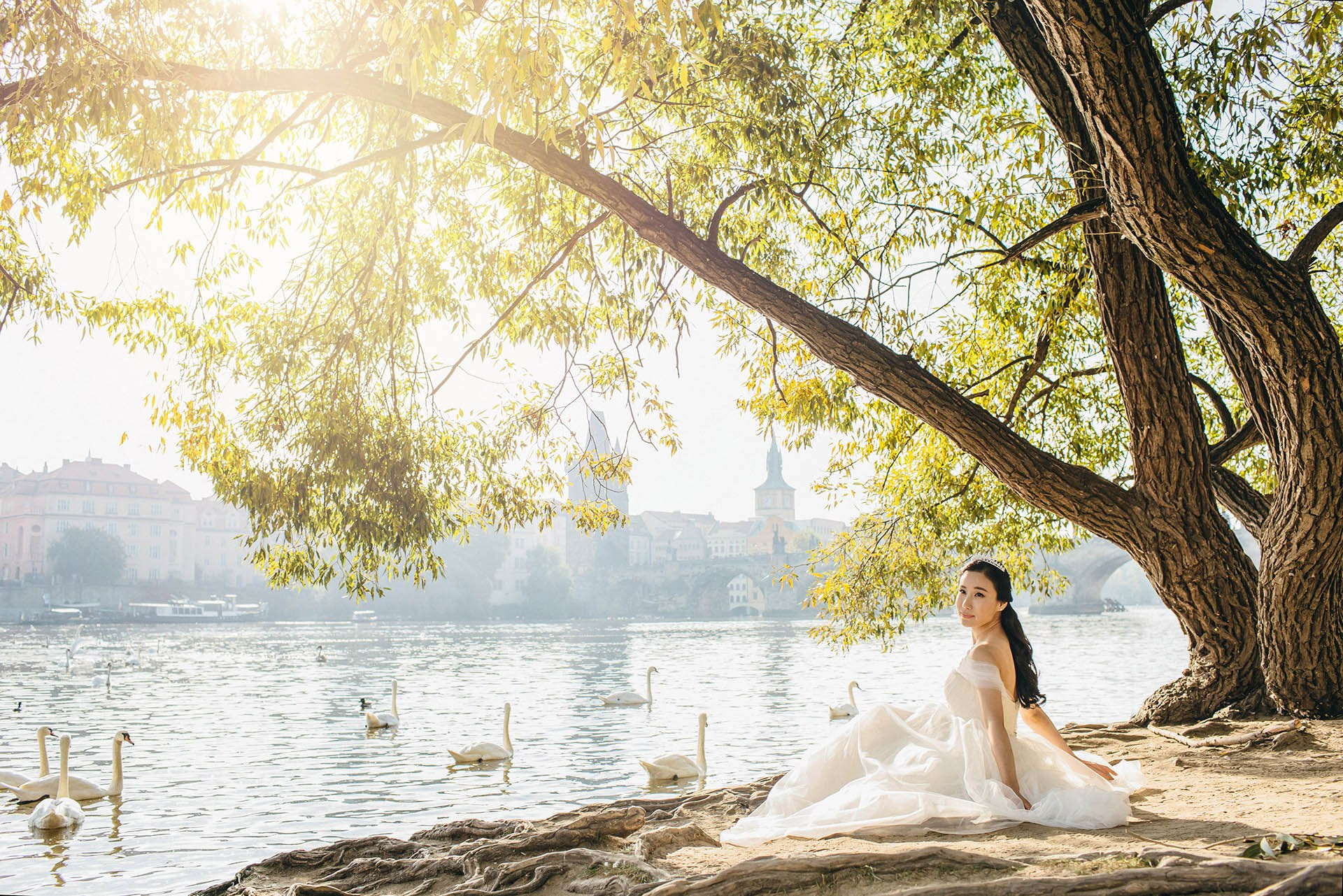 Catherine riverside swans morning sun Prague wedding portrait.