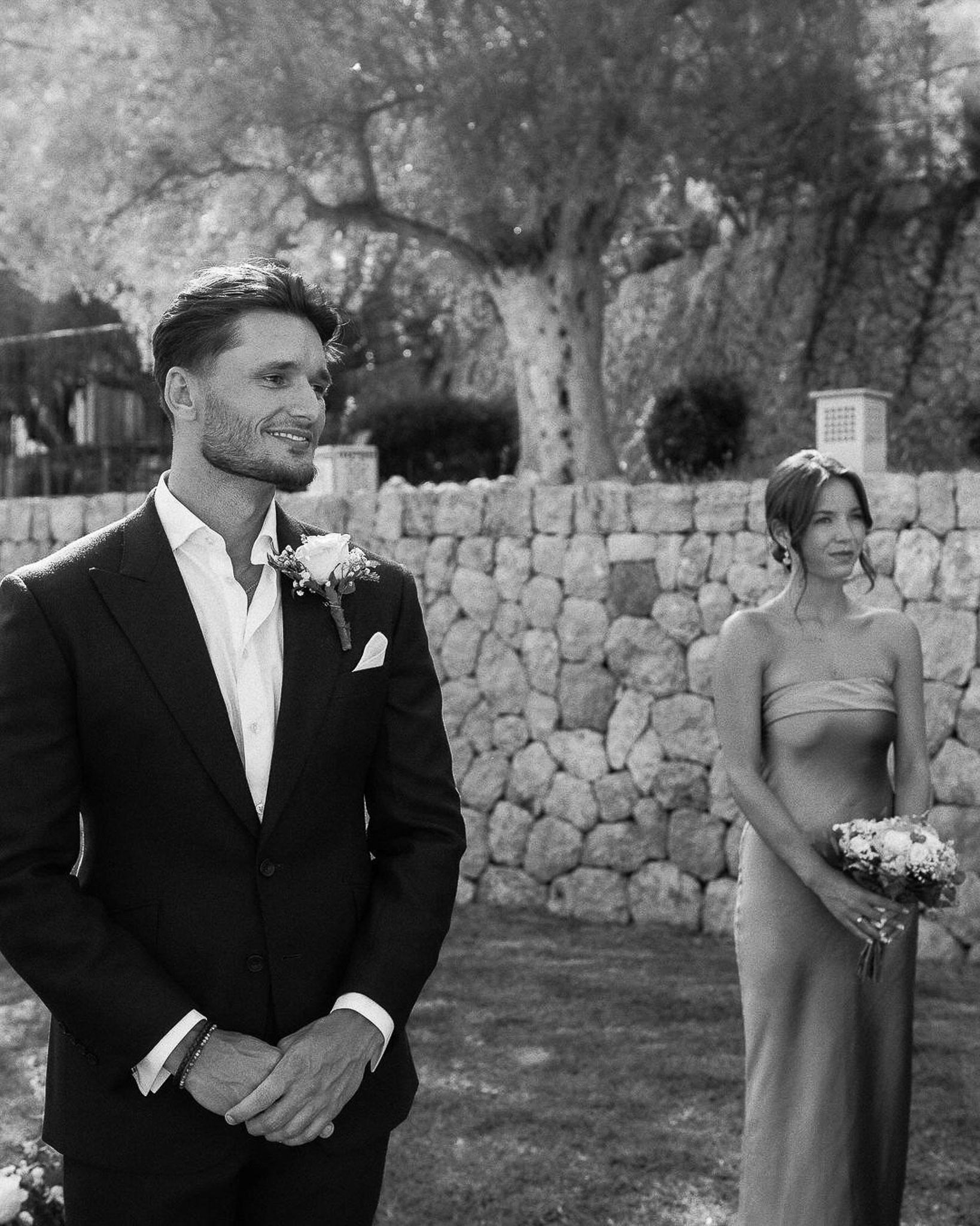 Groom smiling as bride arrives in the garden before their Mallorca wedding ceremony