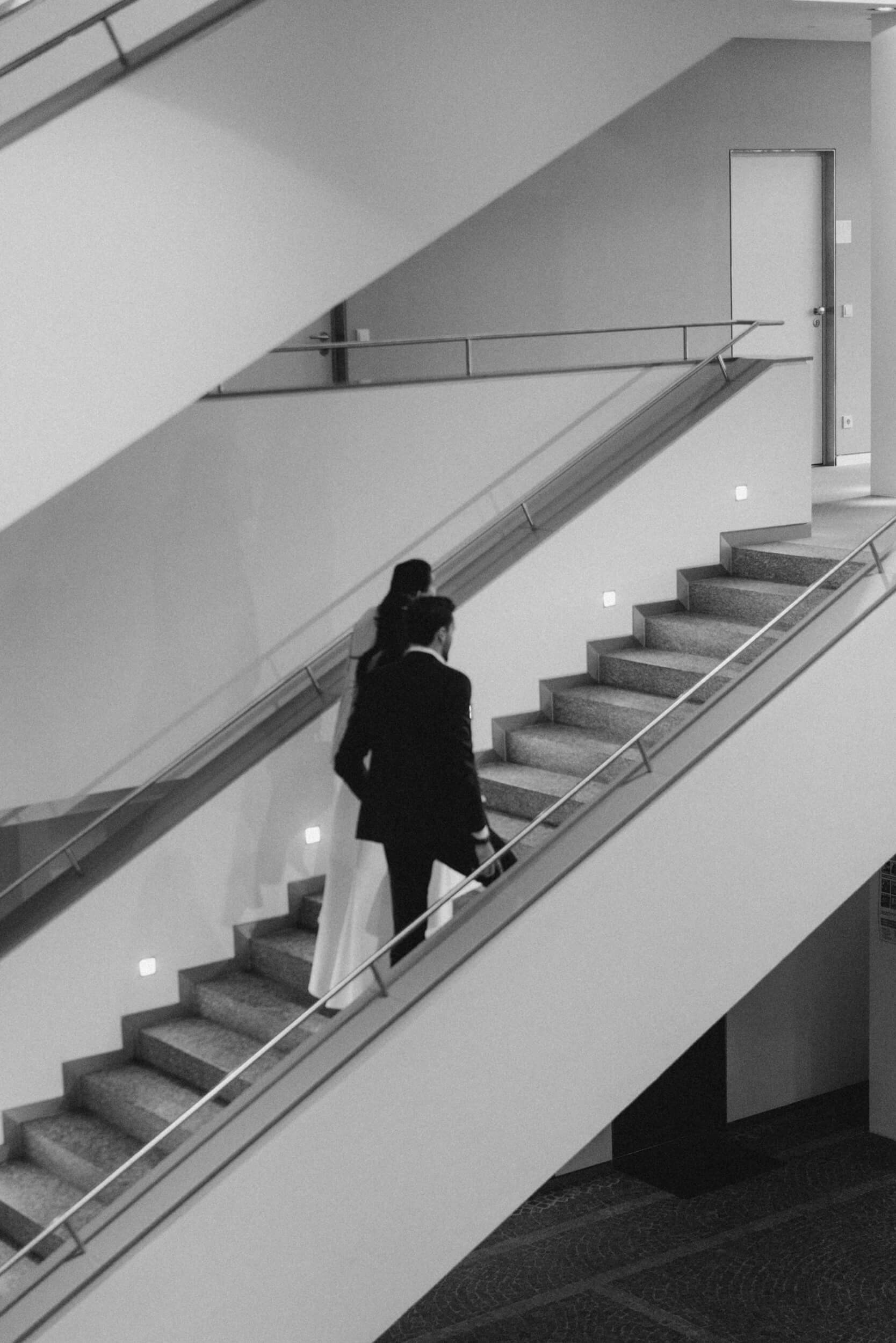 Black and white couple walking upstairs at Standesamt Grünwald