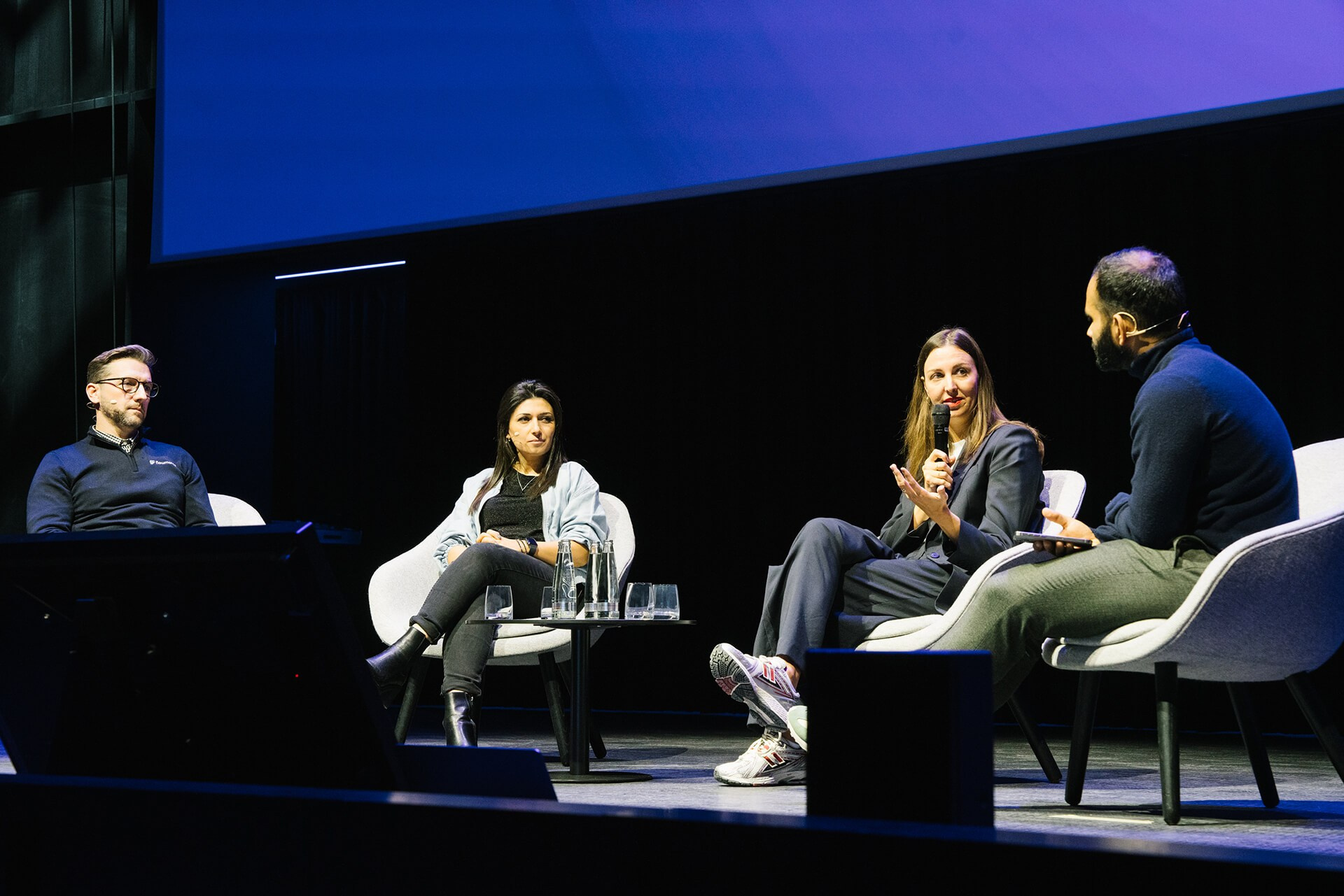 Panel conversation on stage at a Berlin conference with multiple speakers