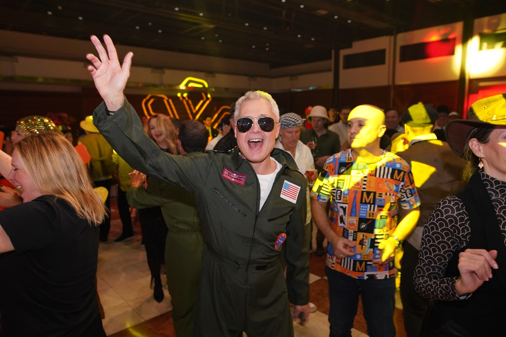 Orange Business attendee in aviator glasses celebrating at adventure-themed awards gala Prague 2026.