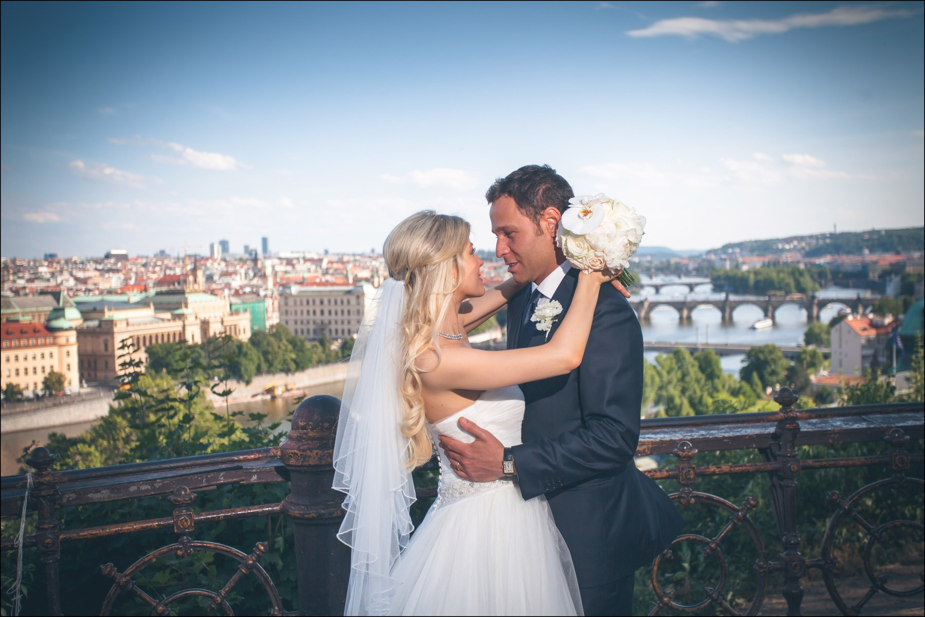 Romantic embrace of newlyweds overlooking Prague skyline