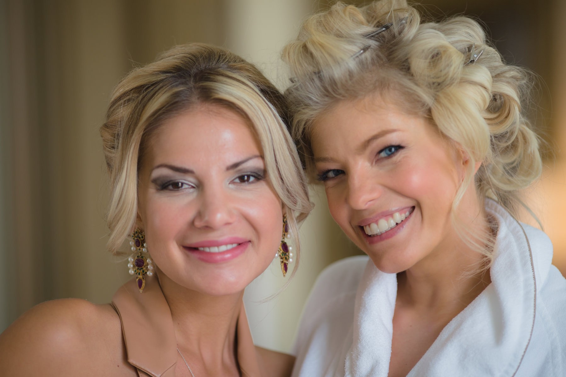 Smiling bridesmaid with bride Julia during intimate getting ready session in Prague