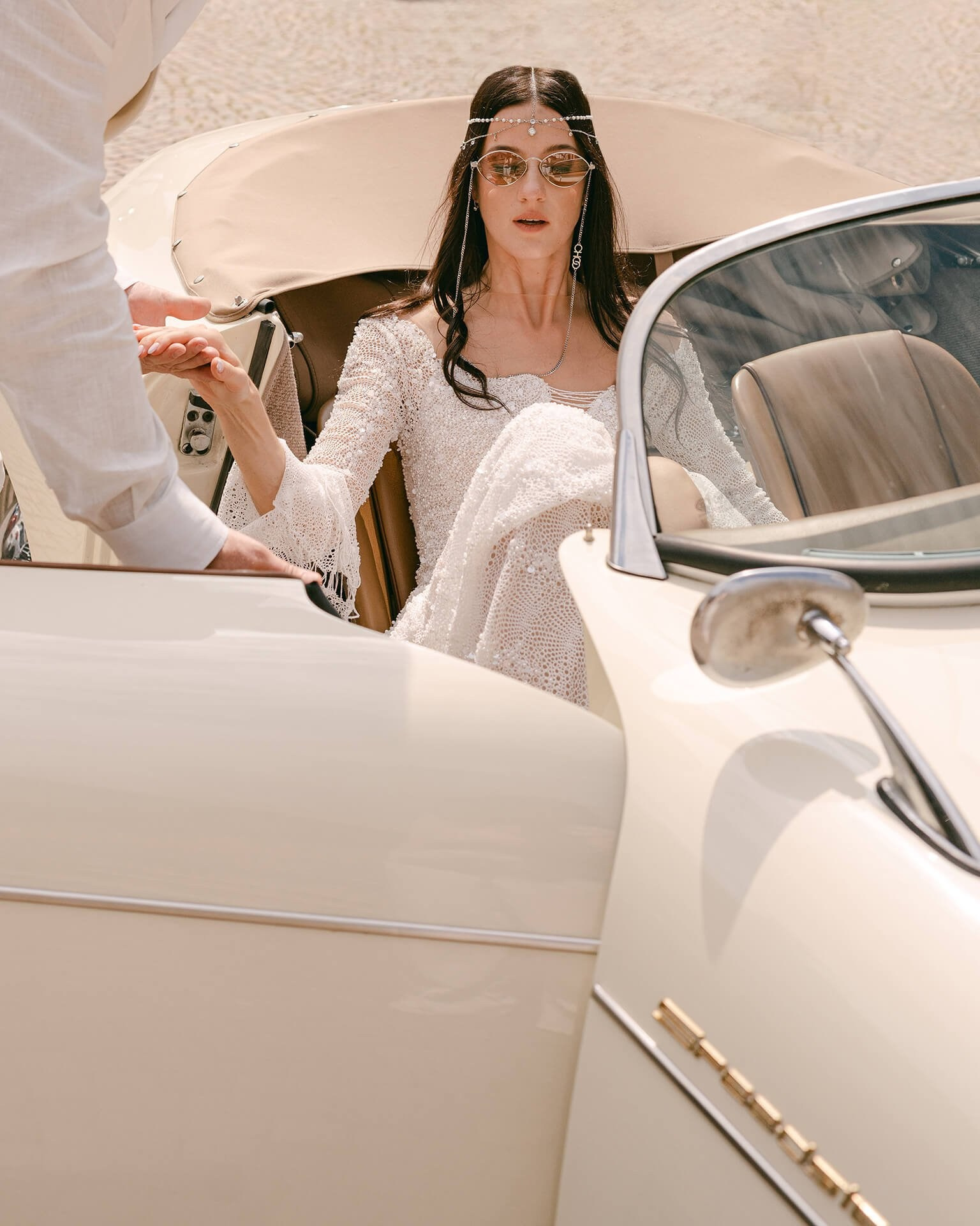 Bride stepping from vintage convertible