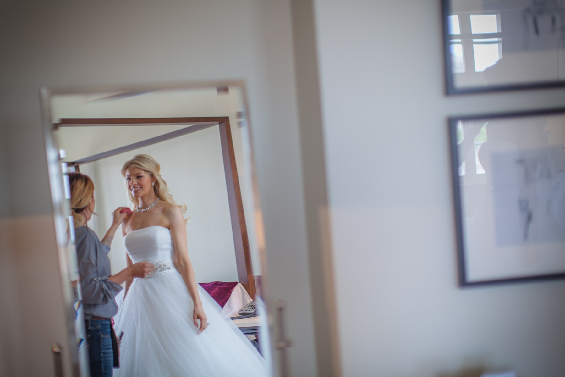 Makeup artist working on beaming bride Julia in suite at Augustine Prague