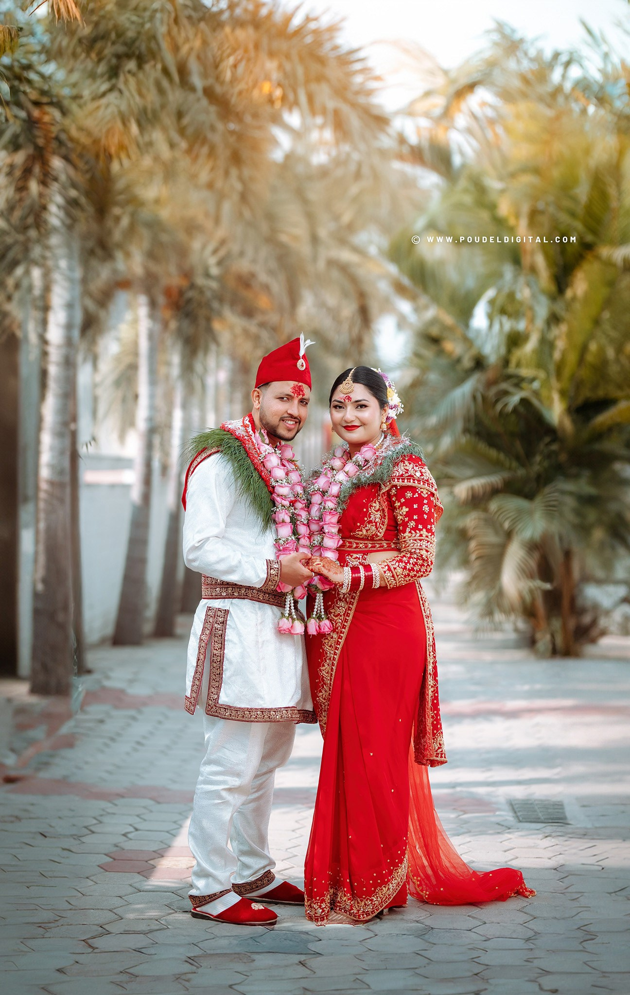 A Nepali bride and groom posing together in traditional wedding ceremony, wearing a red saree, Daura Suruwal, and garlands. Hindu wedding Theme.
