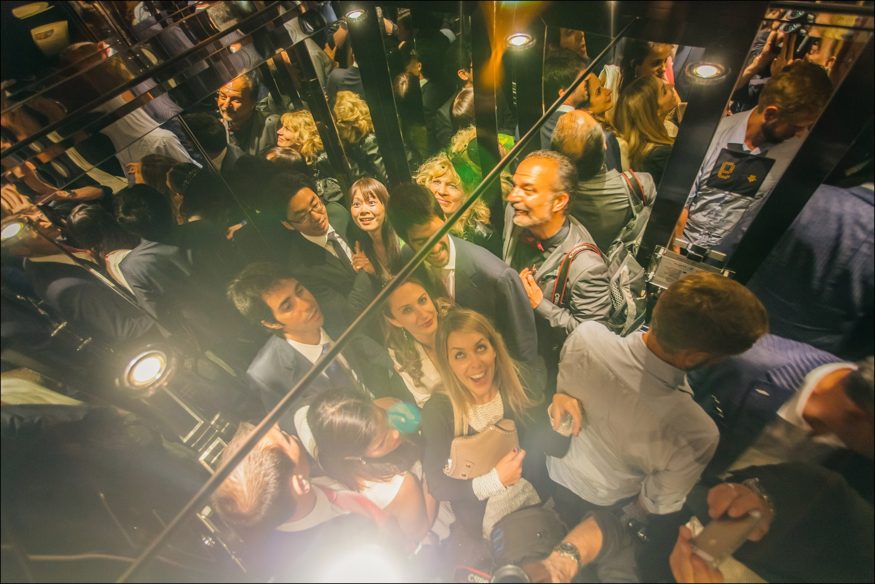 Wedding guests in elevator mirror heading to Sky Bar afterparty Prague