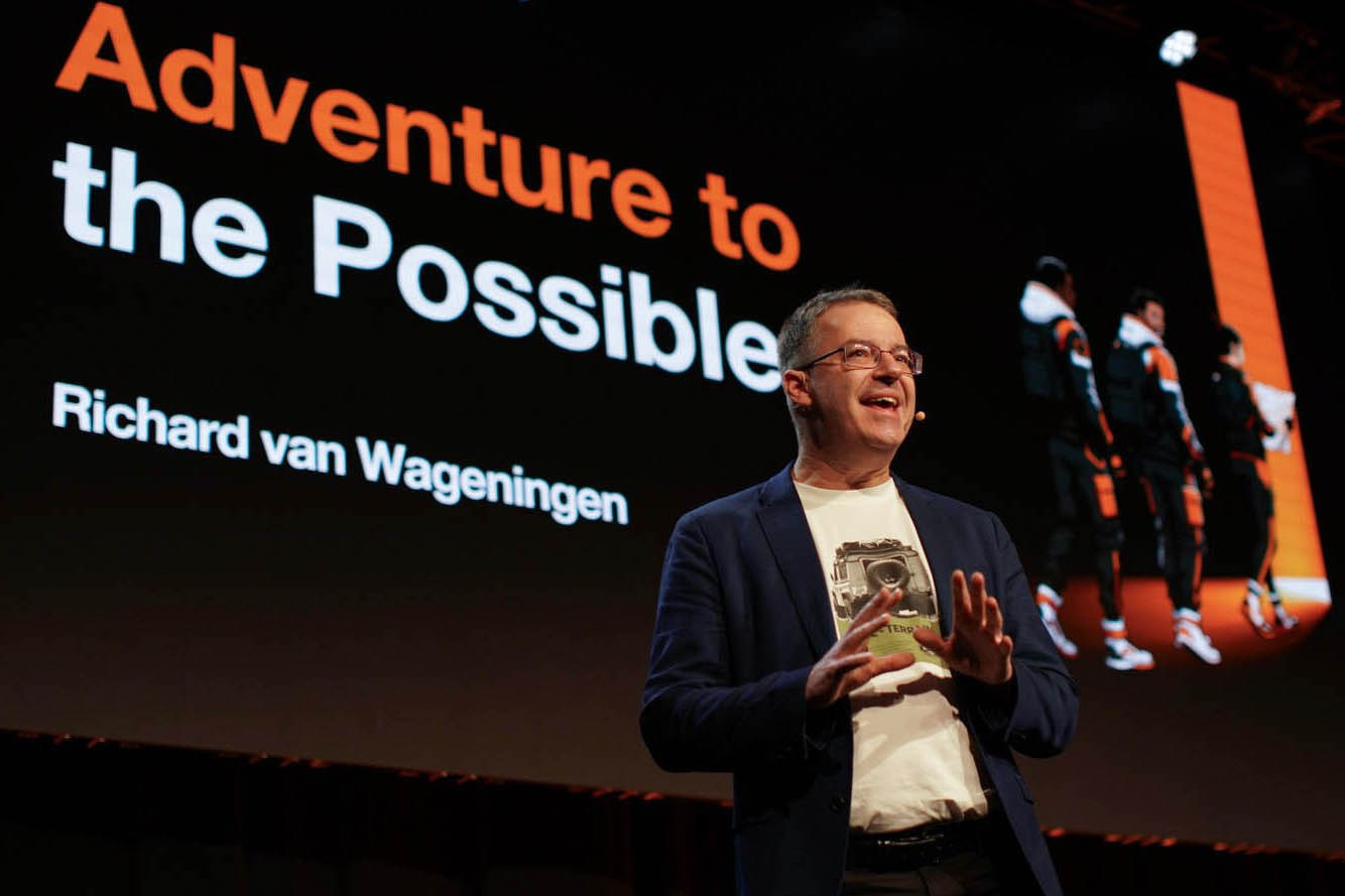 Richard van Wageningen, President Europe Orange Business, speaks on stage with 'Adventure to the Possible' backdrop at 2026 Sales Kick-Off, Hilton Prague.